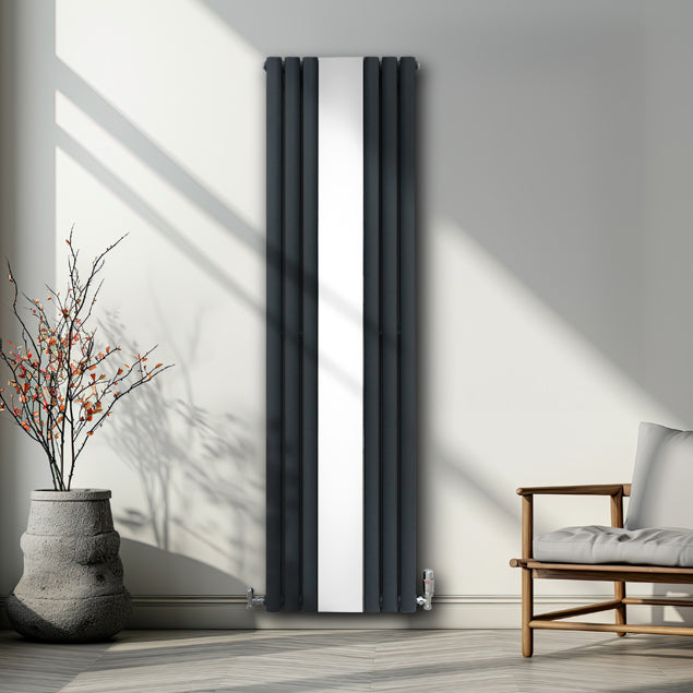Radiateur à colonnes ovales gris anthracite avec un panneau miroir central, installé dans un intérieur moderne et lumineux