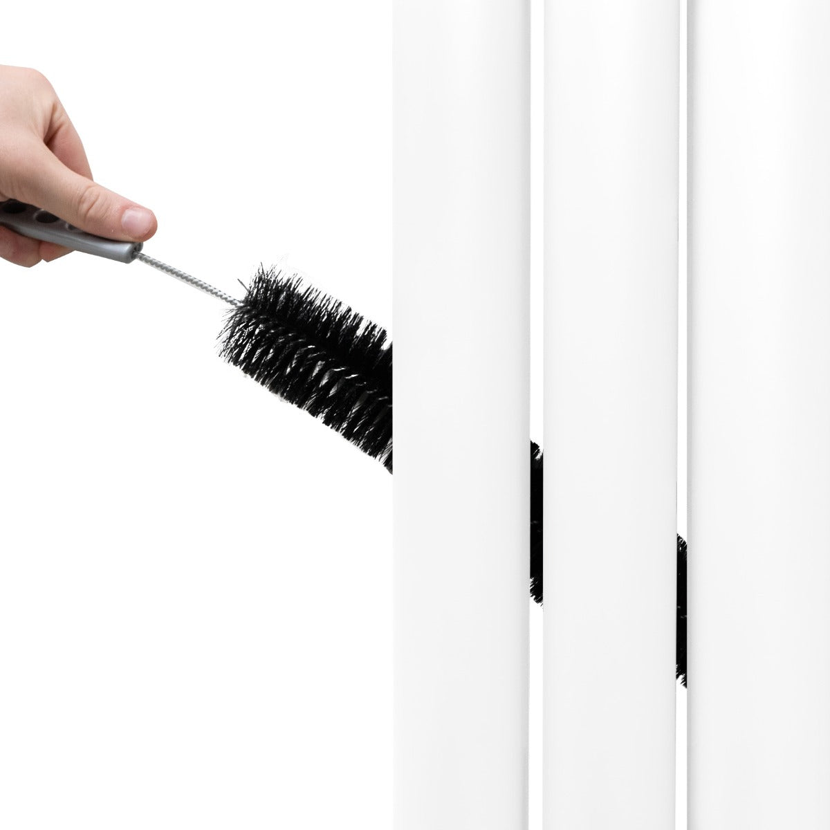 Radiateur à colonnes ovales blanc, nettoyage avec une brosse, mettant en valeur la texture lisse et brillante des panneaux