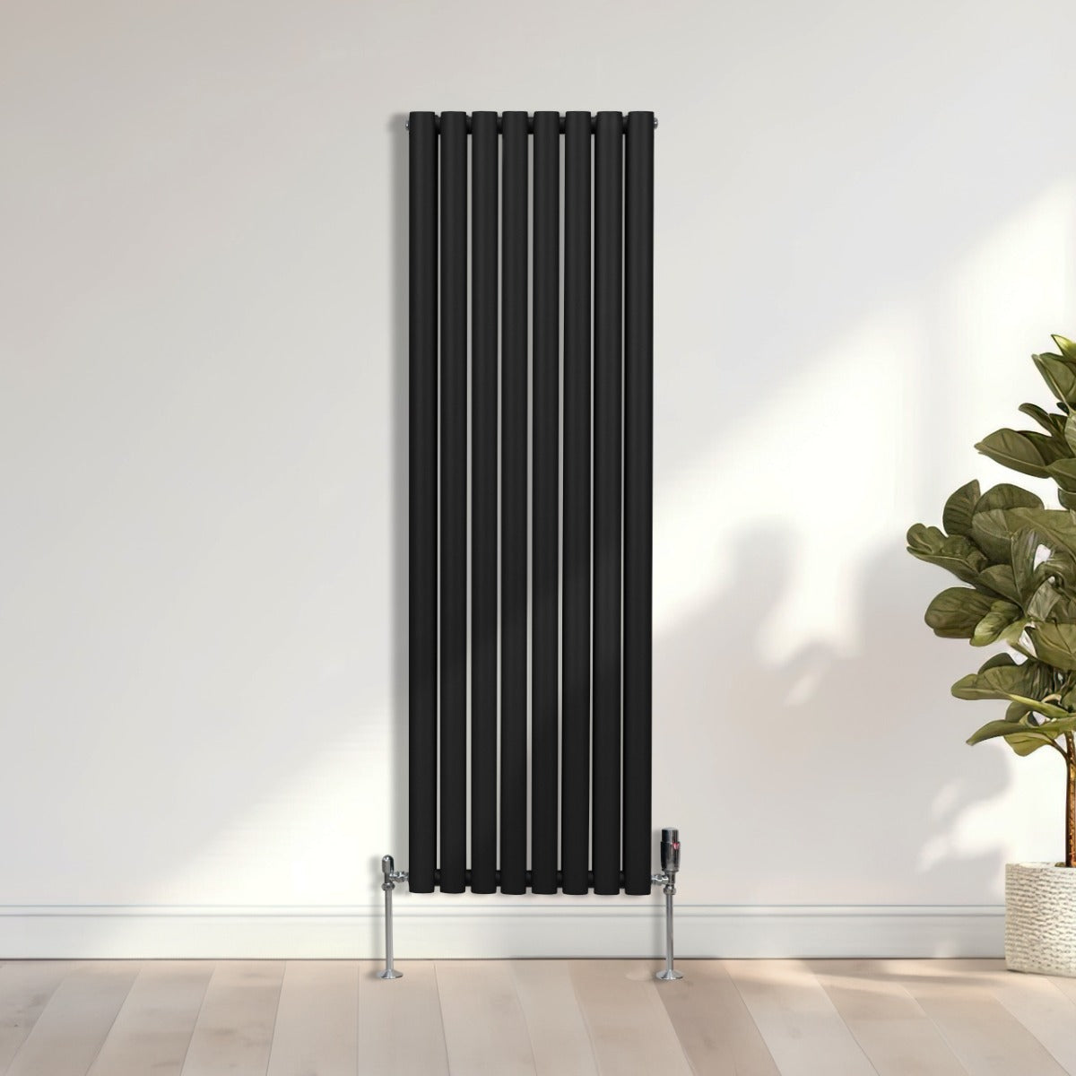 Radiateur à colonnes ovales noir de 1600 x 480 mm avec robinet, finition lisse et moderne, installé contre un mur clair