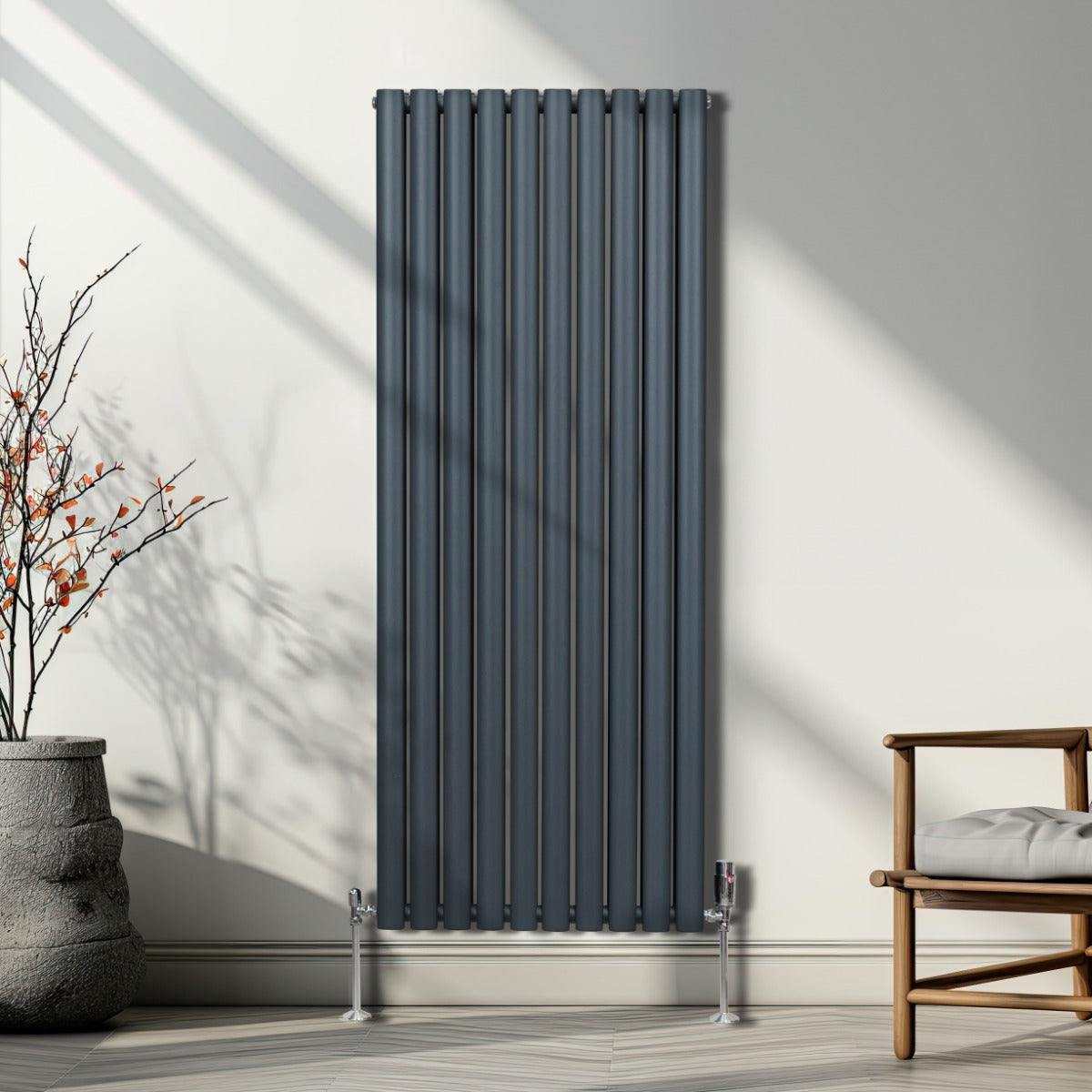 Radiateur à colonnes ovales gris anthracite, 2 panneaux, design moderne, installé contre un mur avec lumière naturelle et plante décorative