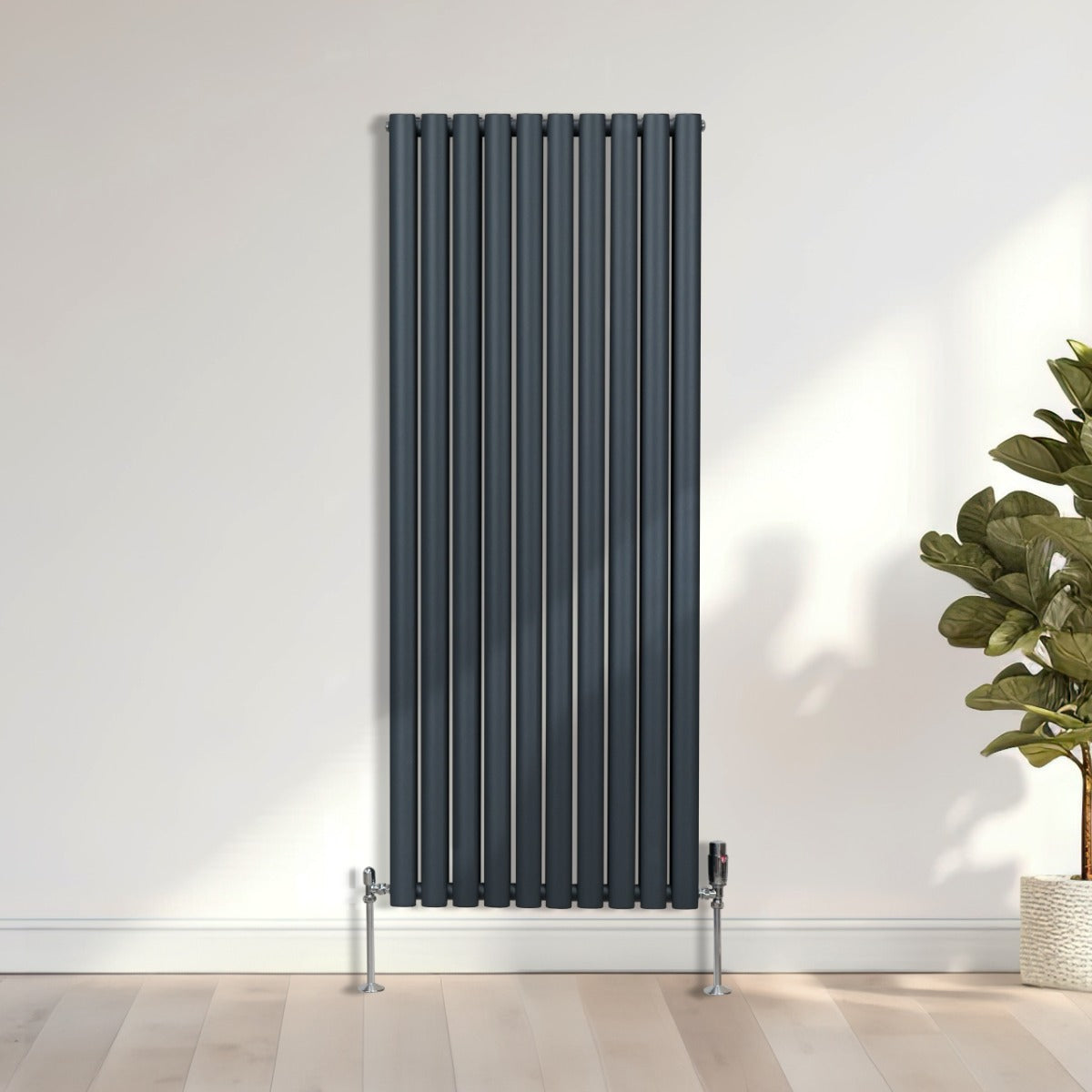 Radiateur à colonnes ovales gris anthracite, 2 panneaux, 1600 x 600 mm, installé contre un mur avec des pieds en métal et un robinet visible