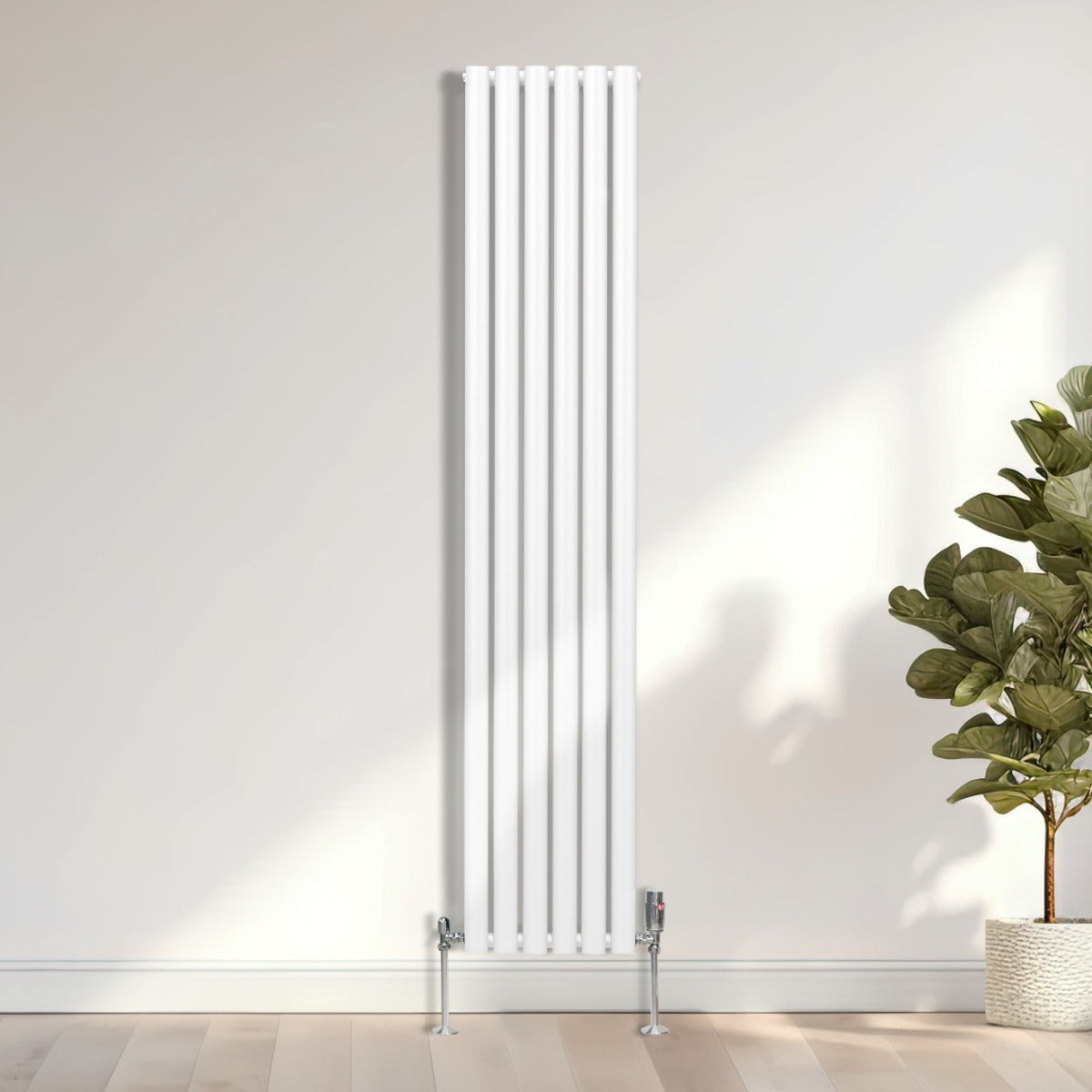 Radiateur à colonnes ovales blanc, 1800 x 360 mm, avec robinet, finition lisse et moderne, installé contre un mur clair avec plante verte