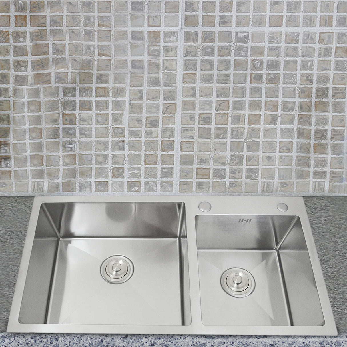Évier double en acier inoxydable avec deux bacs, finition brillante, installé sur un plan de travail en granit, fond en carreaux mosaïques clairs