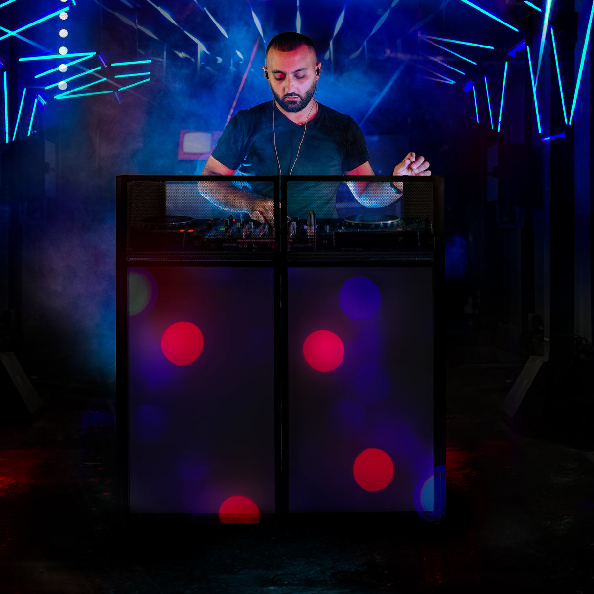 Façade de stand DJ noire avec motifs lumineux multicolores, créant une ambiance festive et dynamique pour les événements nocturnes