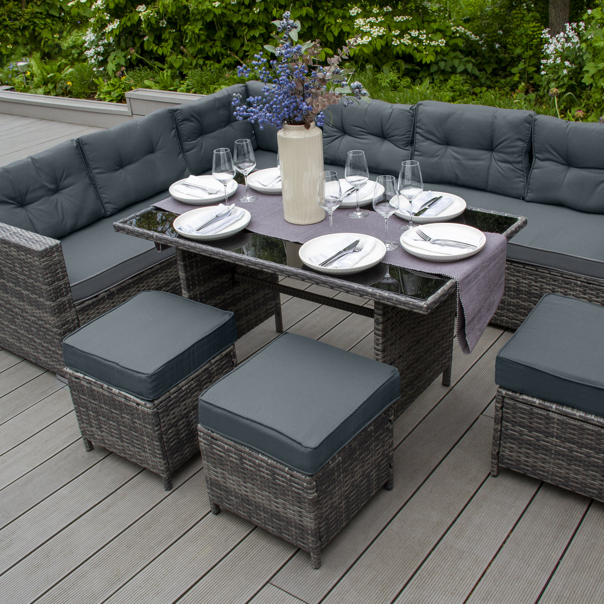 Salon de jardin en rotin gris pour 9 personnes, avec coussins confortables, table en verre et décor floral sur la table