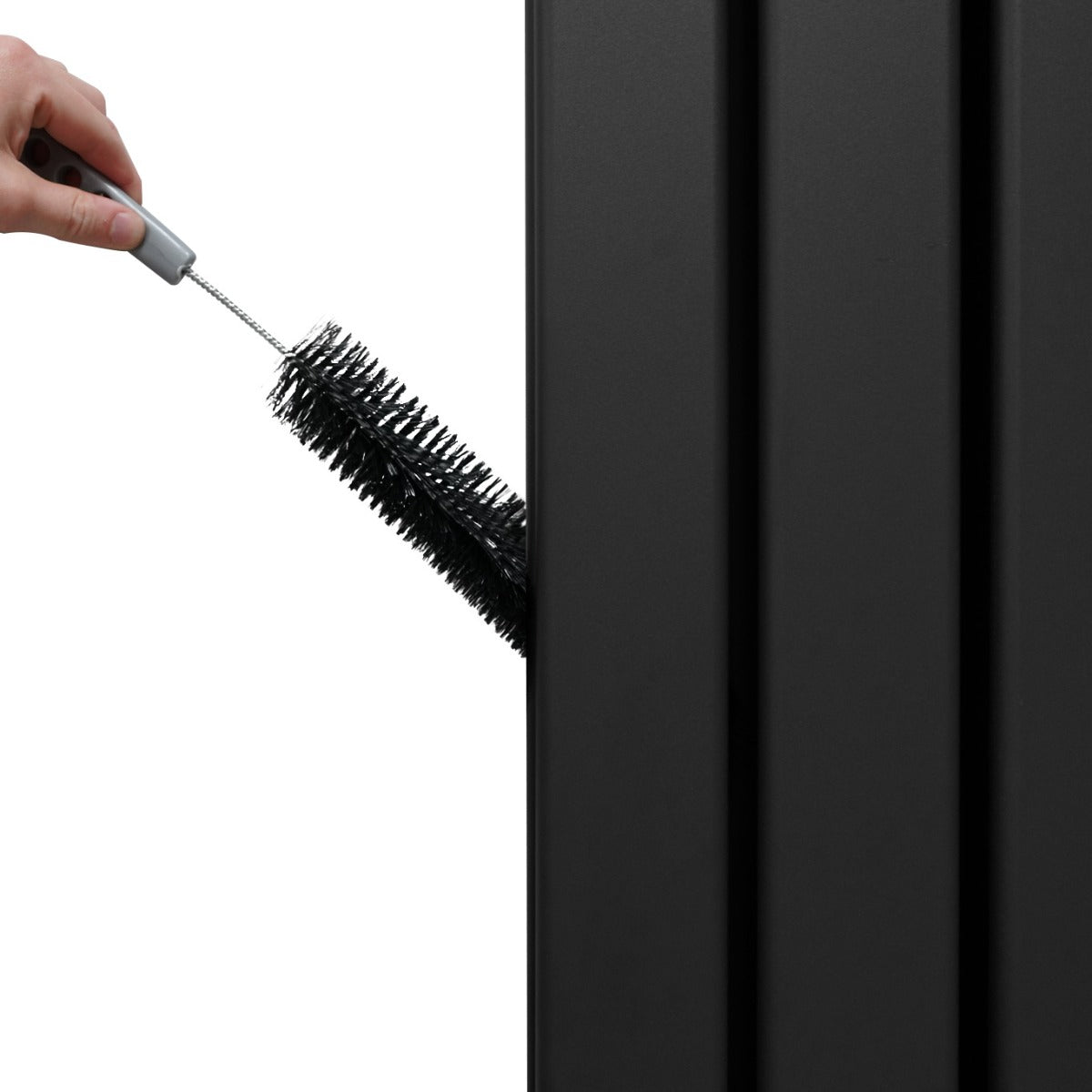 Radiateur plat à miroir noir, 2 panneaux, avec une brosse de nettoyage en cours d'utilisation sur la surface lisse et moderne
