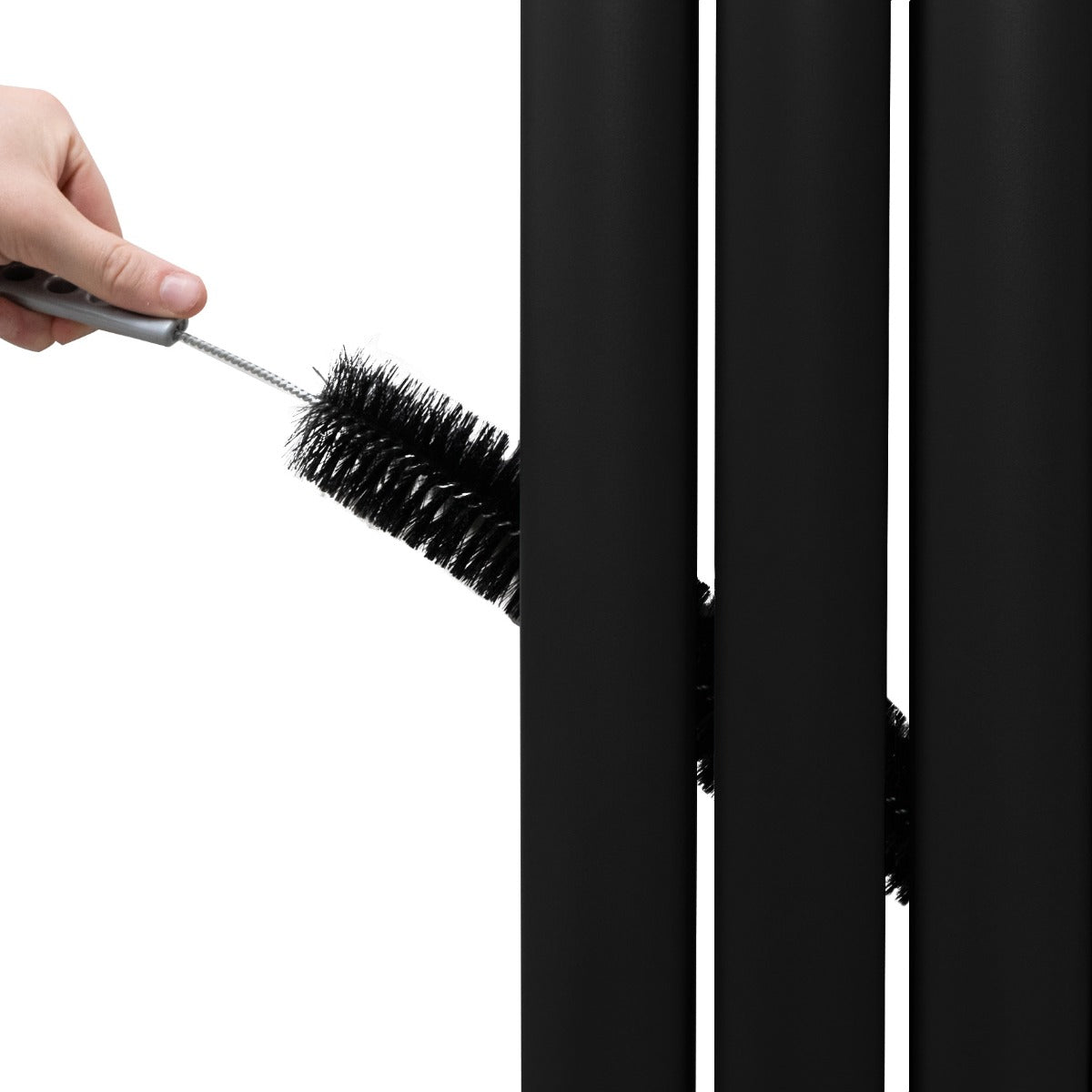 Radiateur à colonnes ovales noir, nettoyage en cours avec une brosse, mettant en valeur la texture lisse et moderne des panneaux