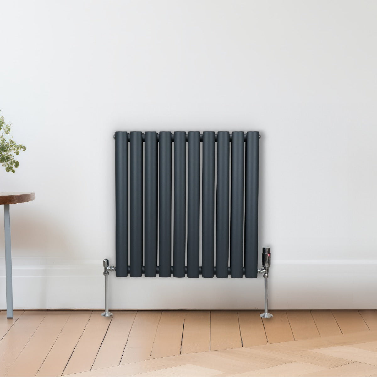 Radiateur à colonnes ovales gris anthracite, 2 panneaux, 600 x 600 mm, avec pieds en métal et design moderne sur un mur clair