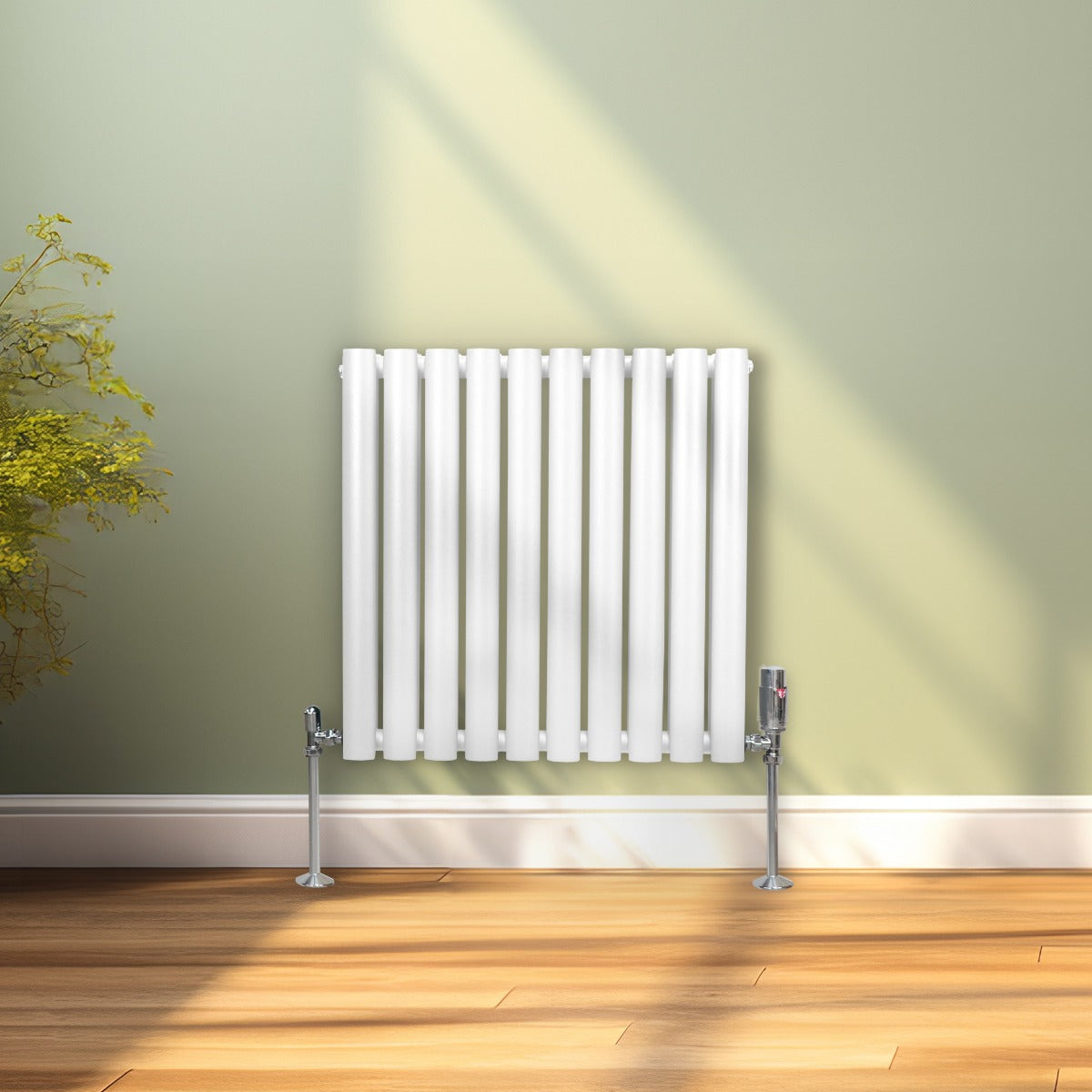Radiateur à colonnes ovales blanc, 2 panneaux, 600 x 600 mm, installé contre un mur vert, avec des pieds en métal argenté et un sol en bois clair