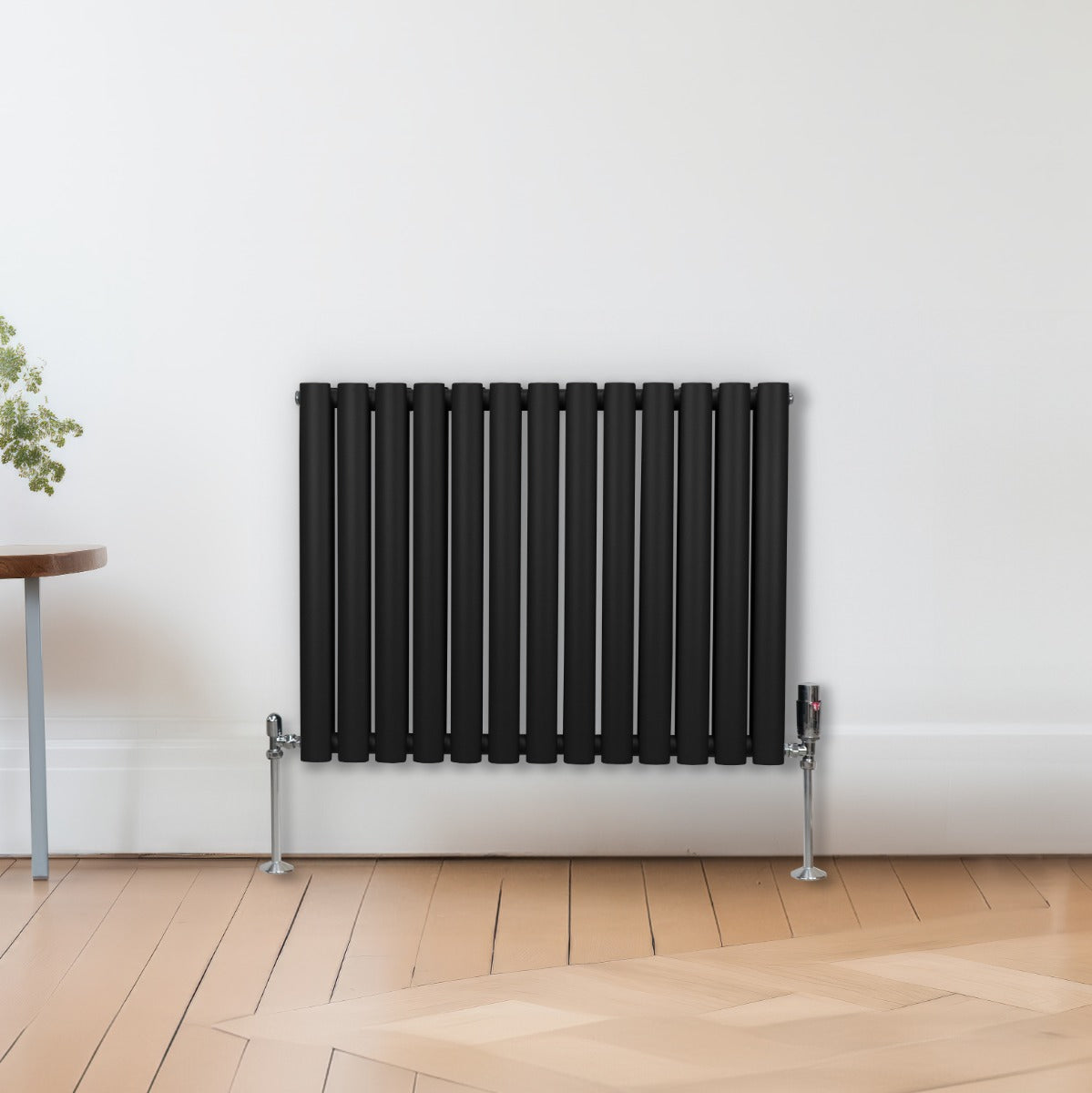 Radiateur à colonnes ovales noir, 2 panneaux, 600 x 780 mm, avec finition lisse et moderne, installé sur un mur clair avec un sol en bois naturel