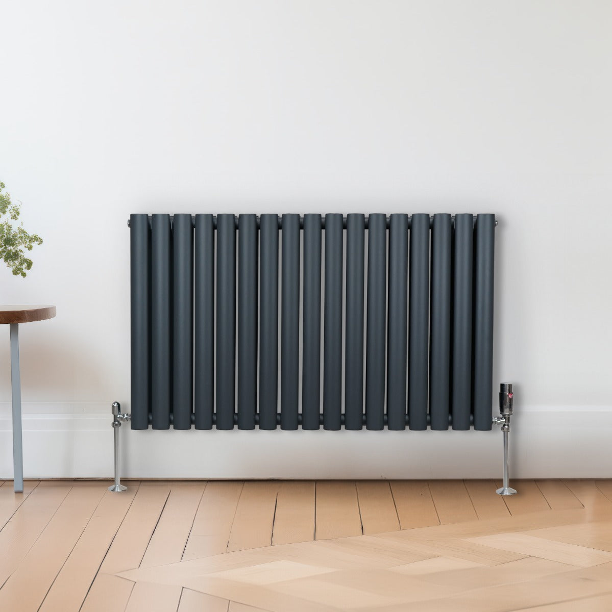 Radiateur à colonnes ovales gris anthracite, 2 panneaux, design moderne avec des lignes épurées, installé sur un sol en bois clair