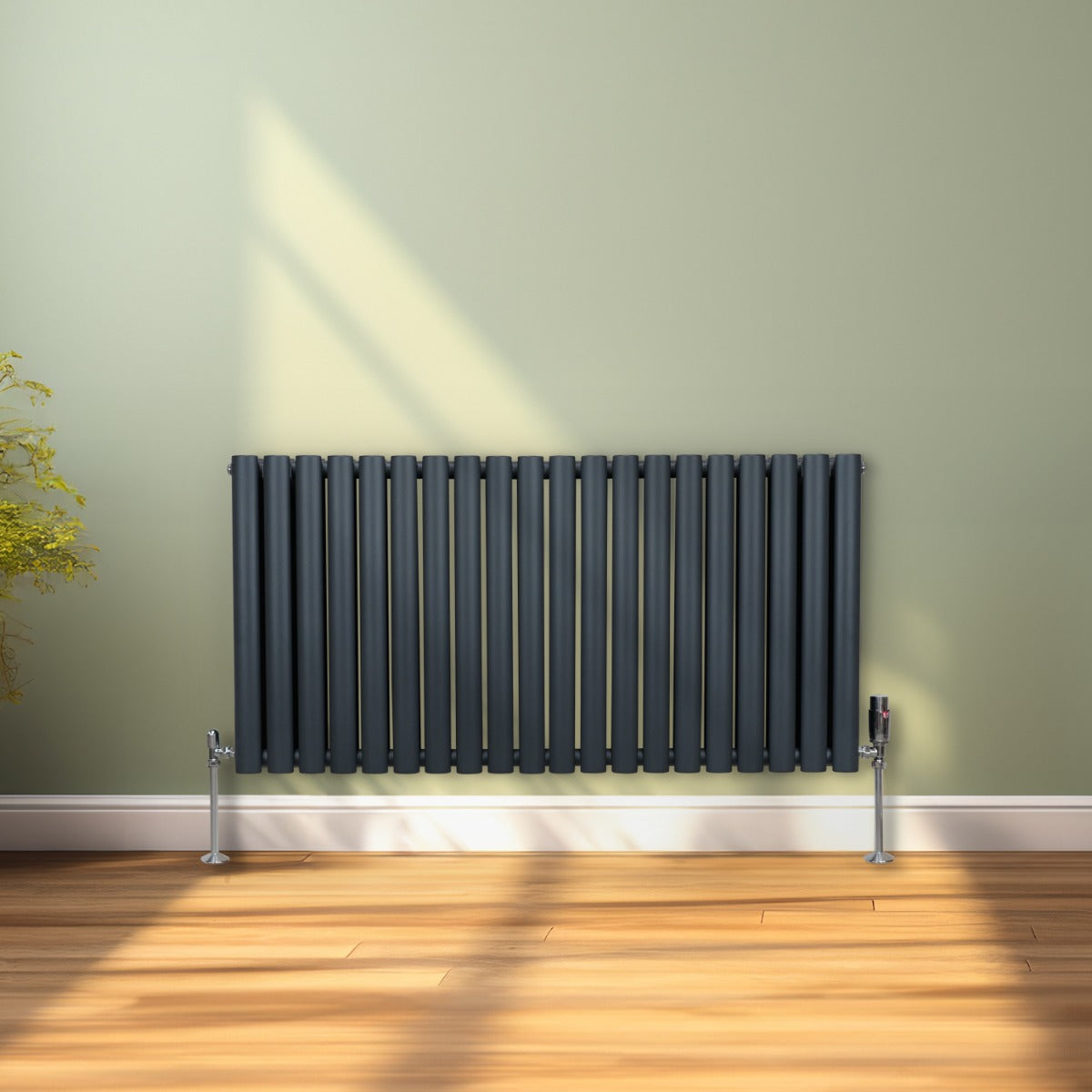 Radiateur à colonnes ovales gris anthracite, 2 panneaux, 600 x 1200 mm, installé sur un mur vert avec un sol en bois clair