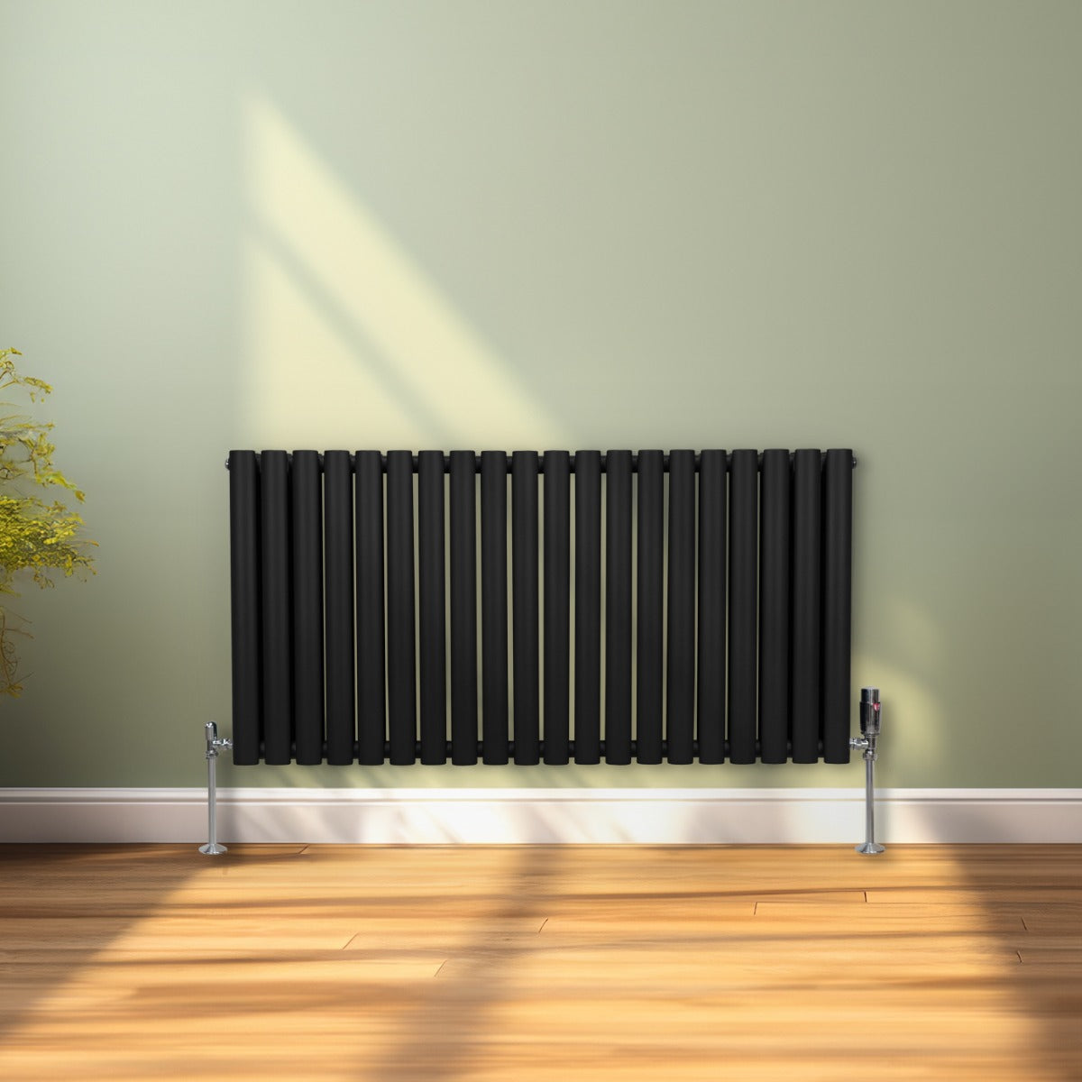 Radiateur à colonnes ovales noir, 600 x 1200 mm, avec deux panneaux, installé sur un mur vert, sol en bois, design moderne et élégant