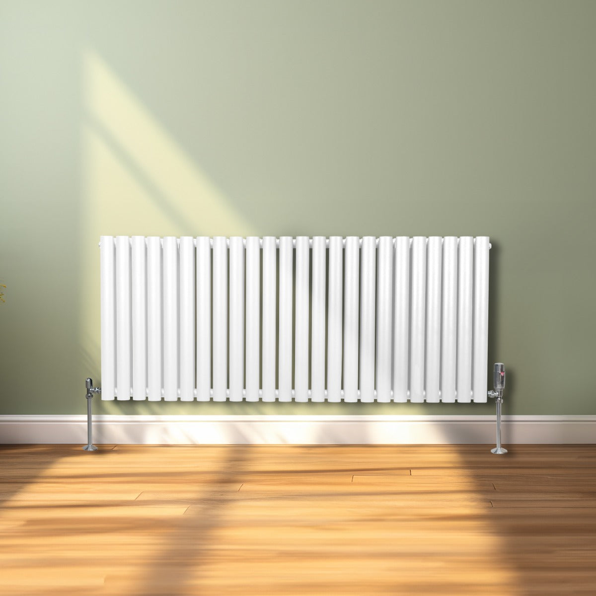 Radiateur à colonnes ovales blanc, 2 panneaux, 600 x 1440 mm, installé sur un sol en bois clair avec un mur vert en arrière-plan