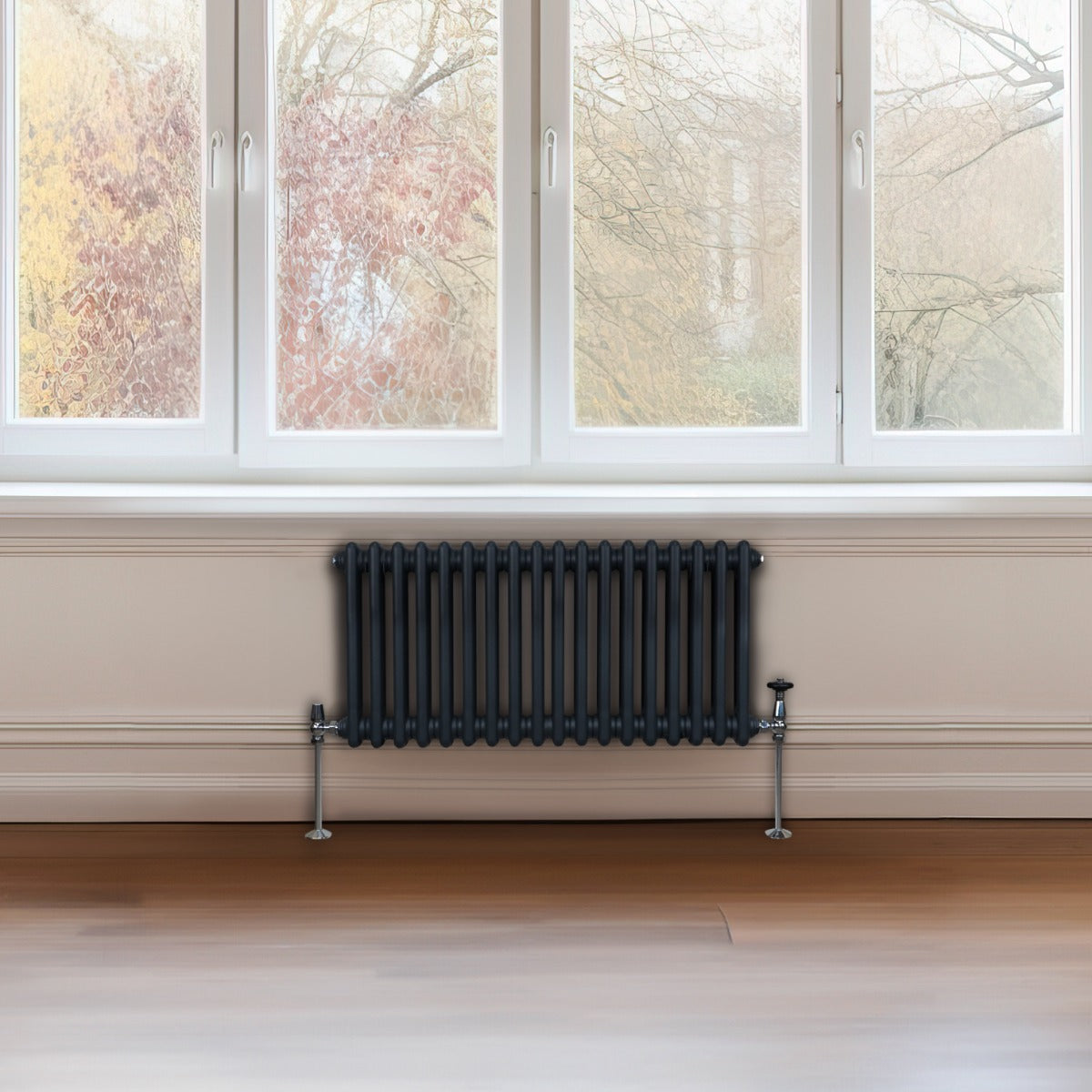 Radiateur traditionnel à 2 colonnes gris anthracite, installé sous une fenêtre, avec un design élégant et des finitions métalliques brillantes