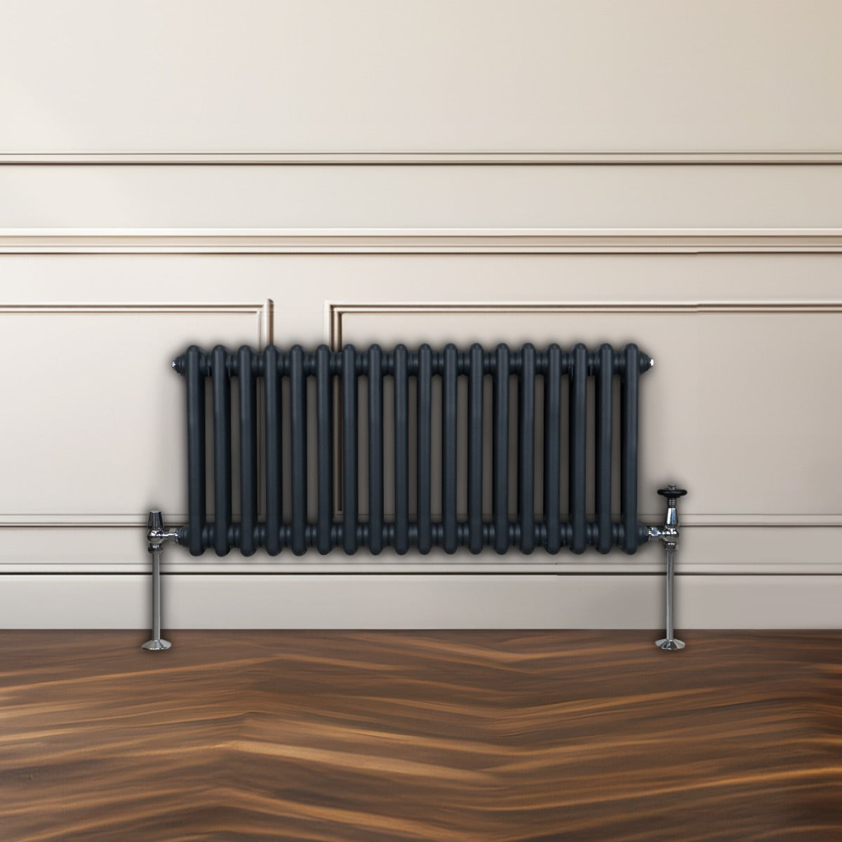 Radiateur traditionnel à 2 colonnes gris anthracite, finition lisse, installé contre un mur avec un sol en bois chaleureux