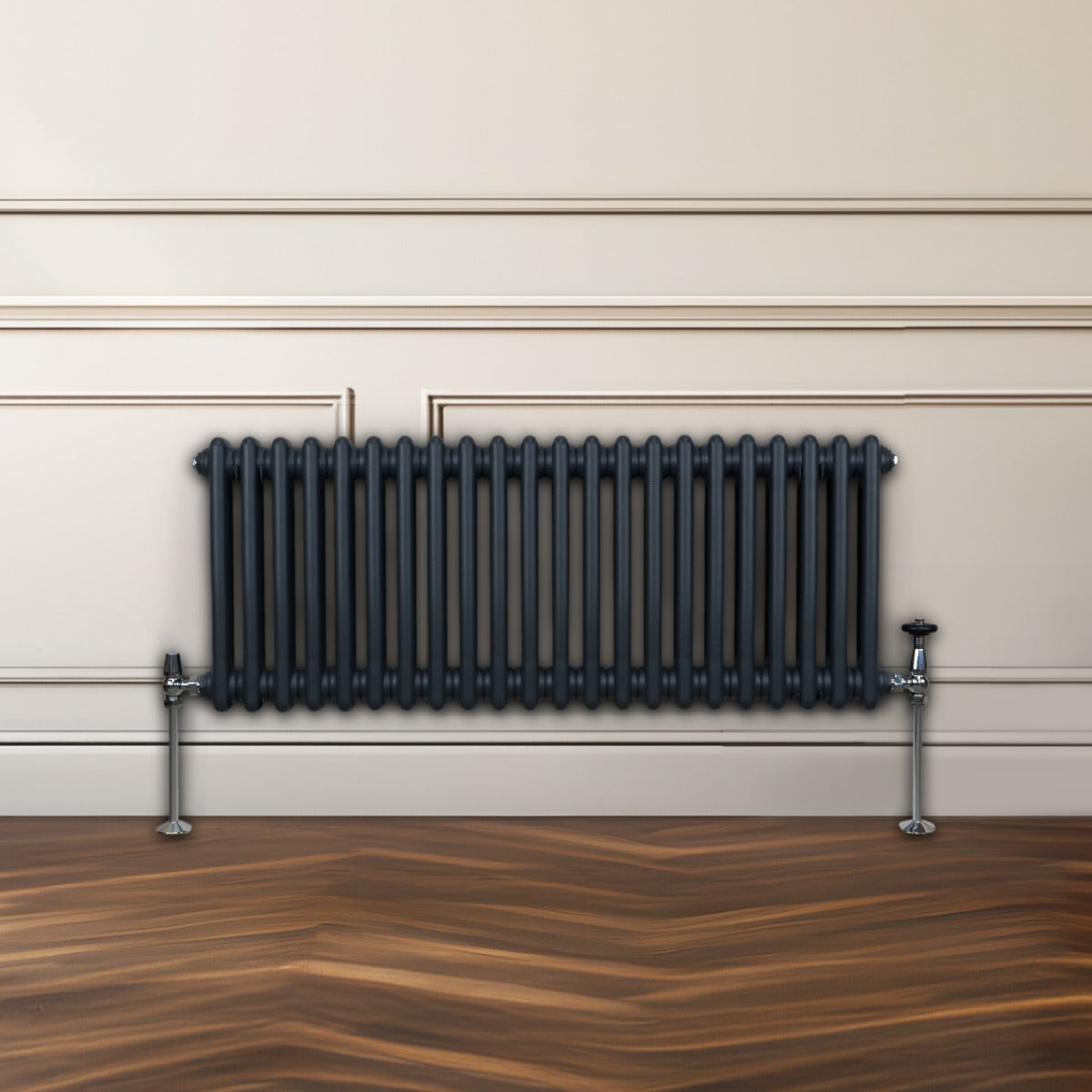 Radiateur traditionnel à 2 colonnes gris anthracite, finition lisse, installé contre un mur avec un sol en bois élégant