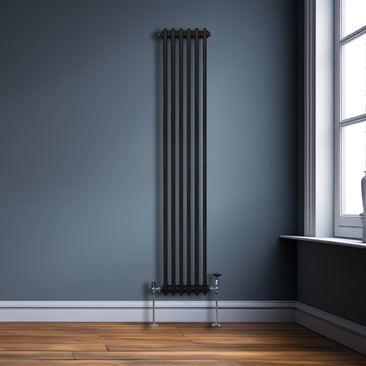 Radiateur traditionnel noir à deux colonnes, 1800 x 292 mm, avec une finition lisse, installé contre un mur bleu, sur un sol en bois