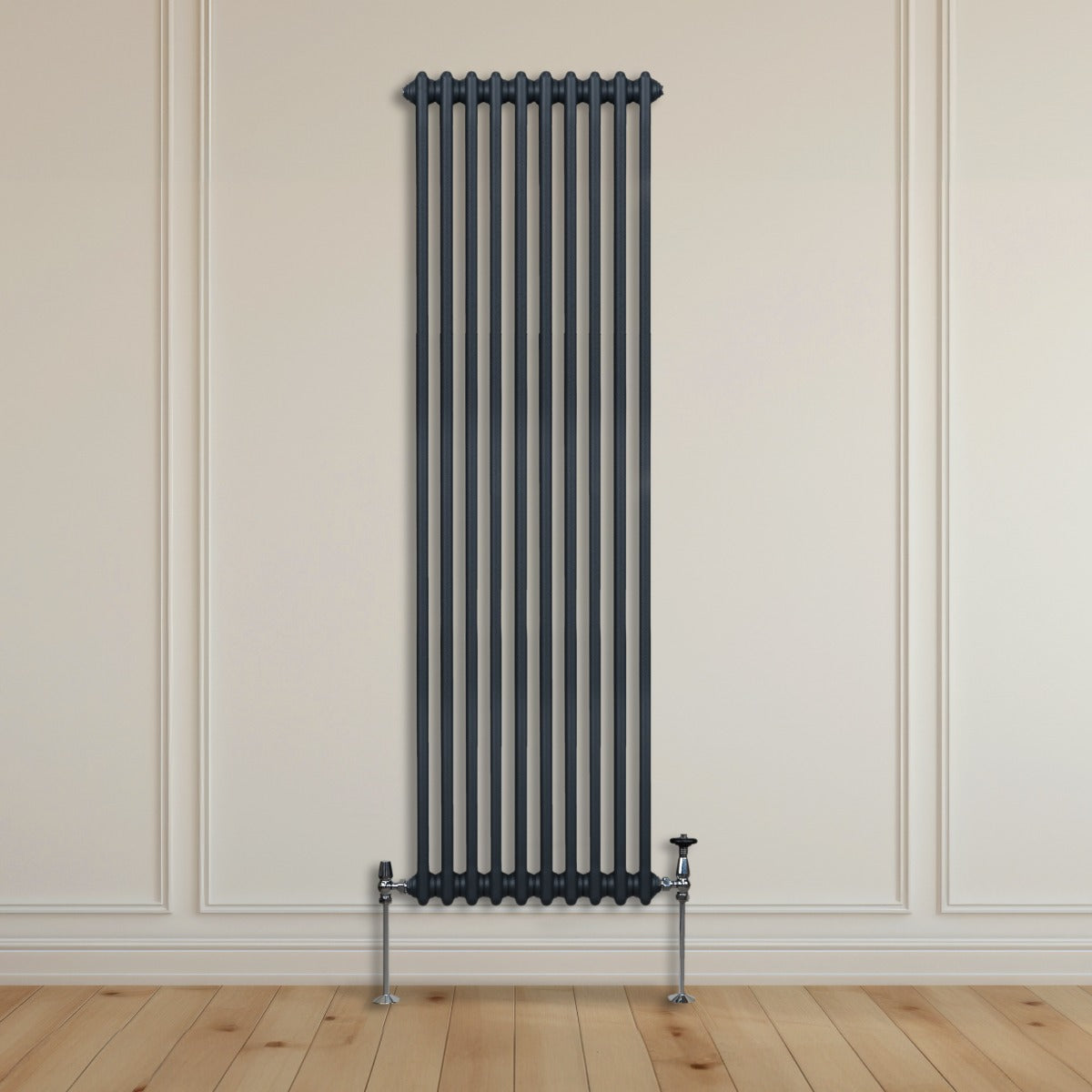 Radiateur traditionnel à 2 colonnes gris anthracite, haut et étroit, installé sur un mur clair avec un sol en bois naturel