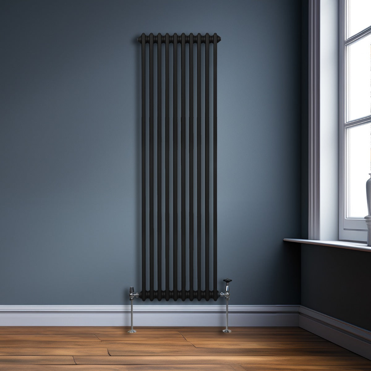 Radiateur traditionnel noir à 2 colonnes, 1800 x 472 mm, installé sur un mur bleu, avec un sol en bois clair et des détails métalliques brillants