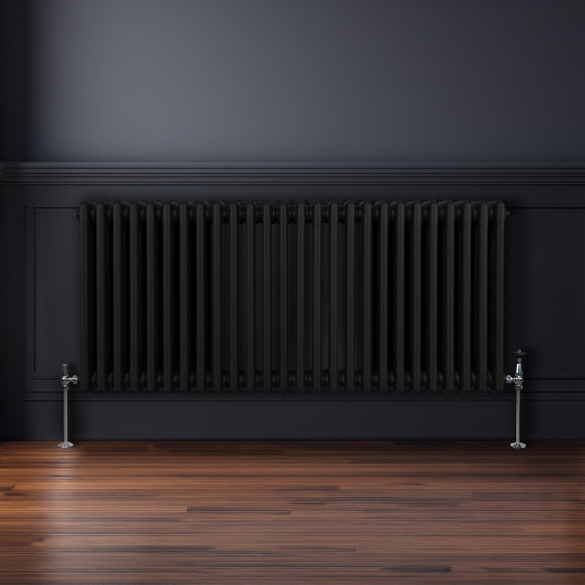 Radiateur traditionnel noir à trois colonnes, 600 x 1192 mm, installé sur un mur sombre avec un sol en bois élégant