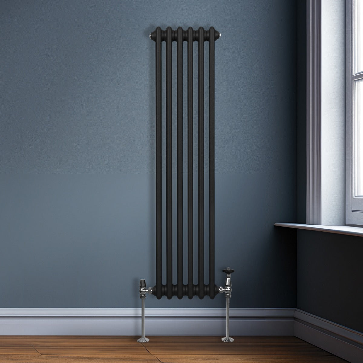 Radiateur traditionnel noir à 3 colonnes, 1500 x 292 mm, installé sur un mur bleu avec des tuyaux chromés et un sol en bois clair