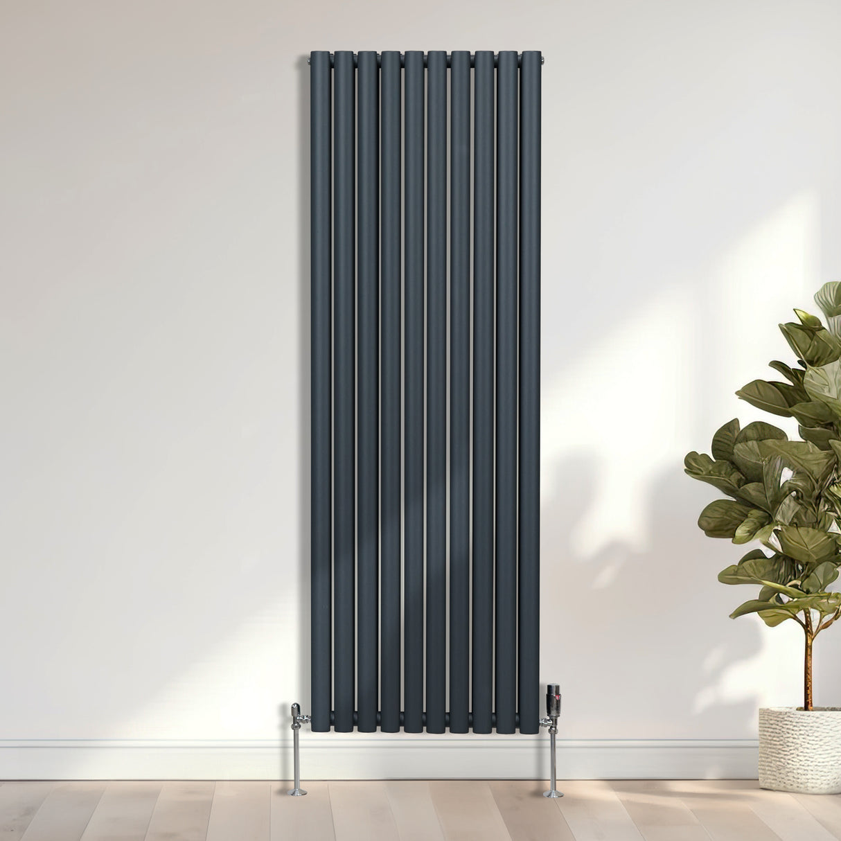 Vanne de radiateur thermostatique en laiton chromé, finition brillante, design moderne, installée sur un mur clair avec un radiateur vertical élégant