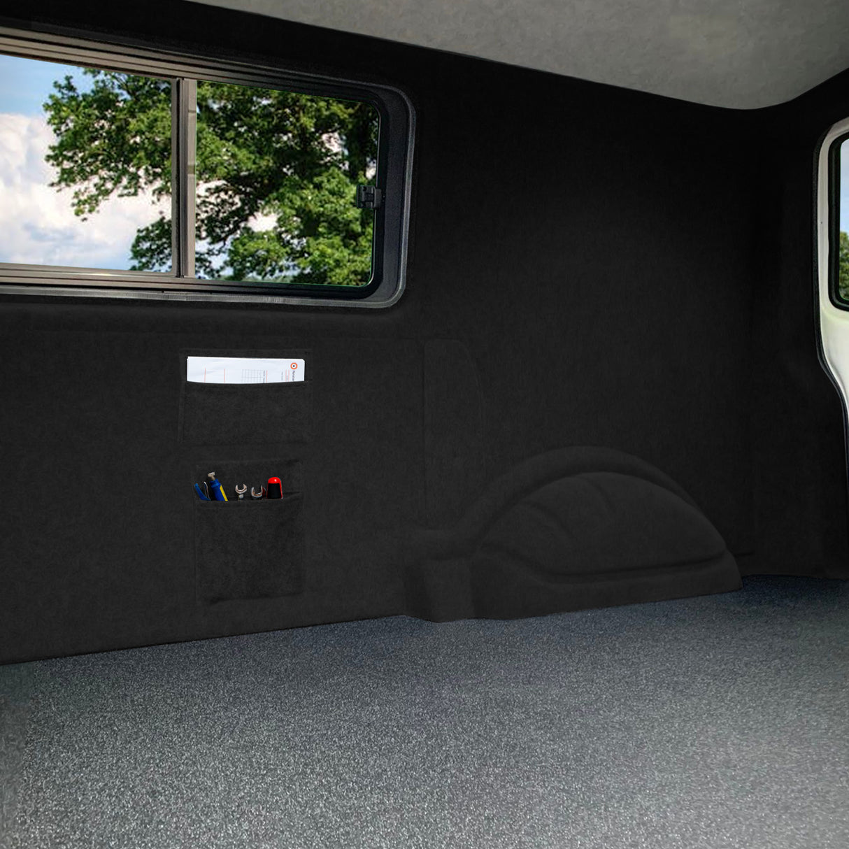 Poches de rangement noires en tissu, fixées au mur, offrant un espace de stockage pratique pour outils et accessoires dans un intérieur sombre et moderne
