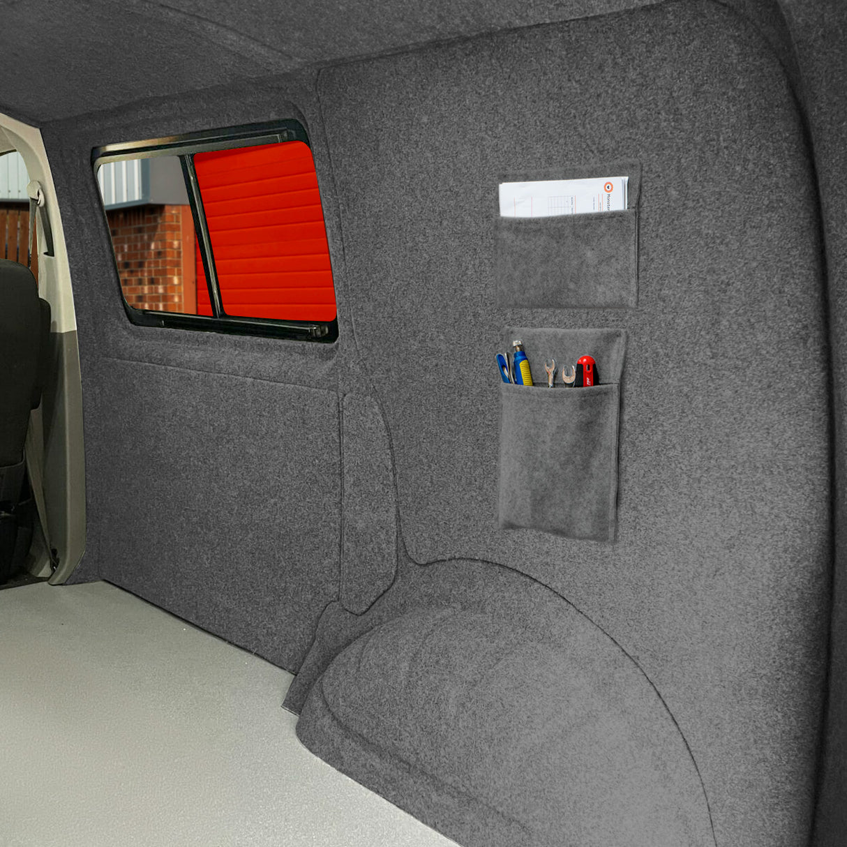 Poches de rangement gris clair en tissu doux, fixées sur un mur intérieur, offrant un espace pour stylos et outils
