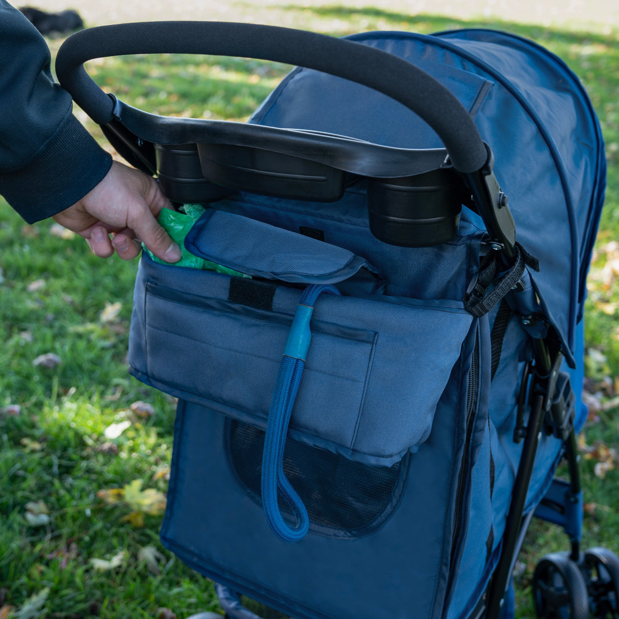 Sac caddy bleu marine pour poussette d'animal, avec poches pratiques et texture résistante, idéal pour ranger accessoires et friandises