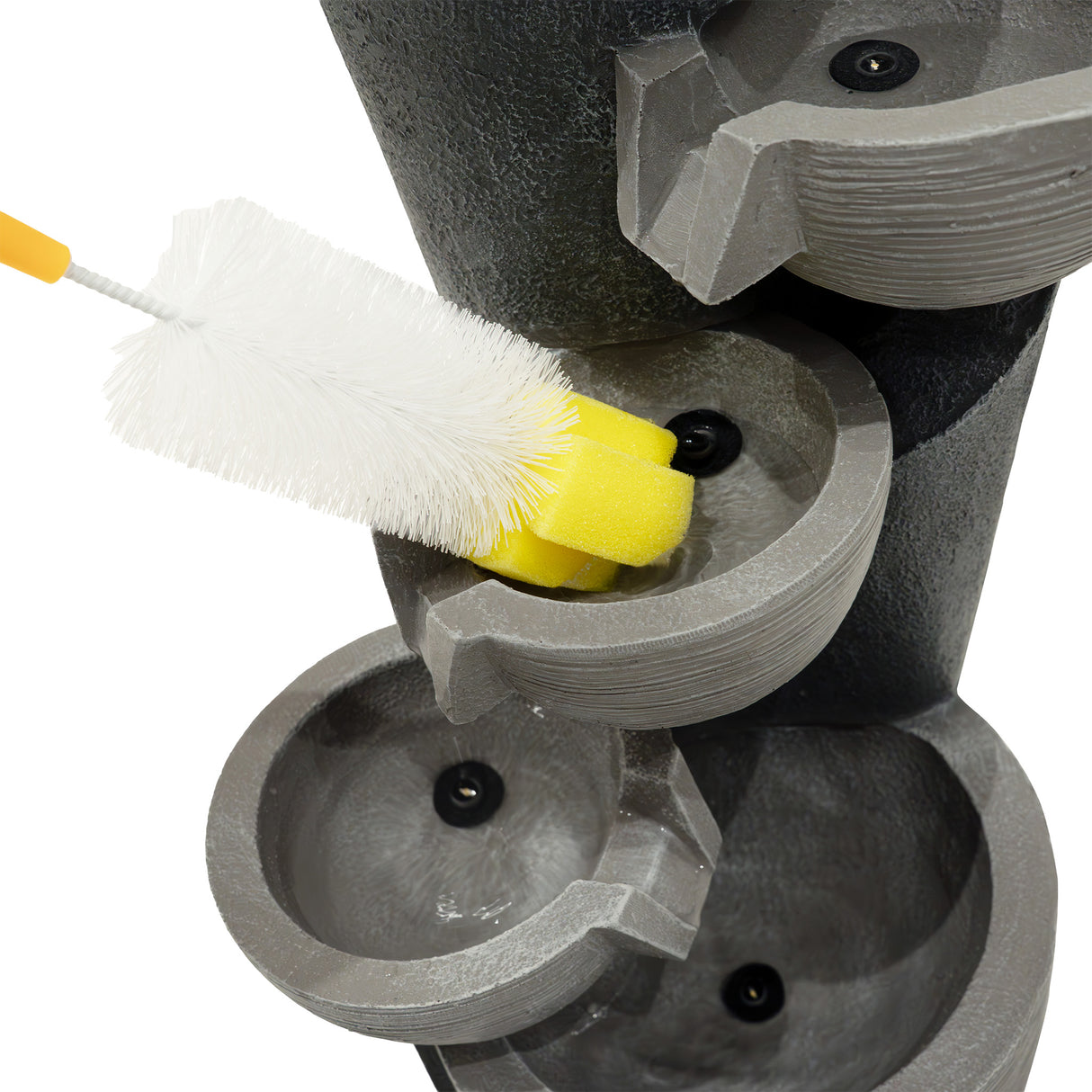 Brosse de nettoyage jaune sur les bassins en béton gris de la fontaine de jardin « Illusion Lagoon » avec éclairage LED intégré