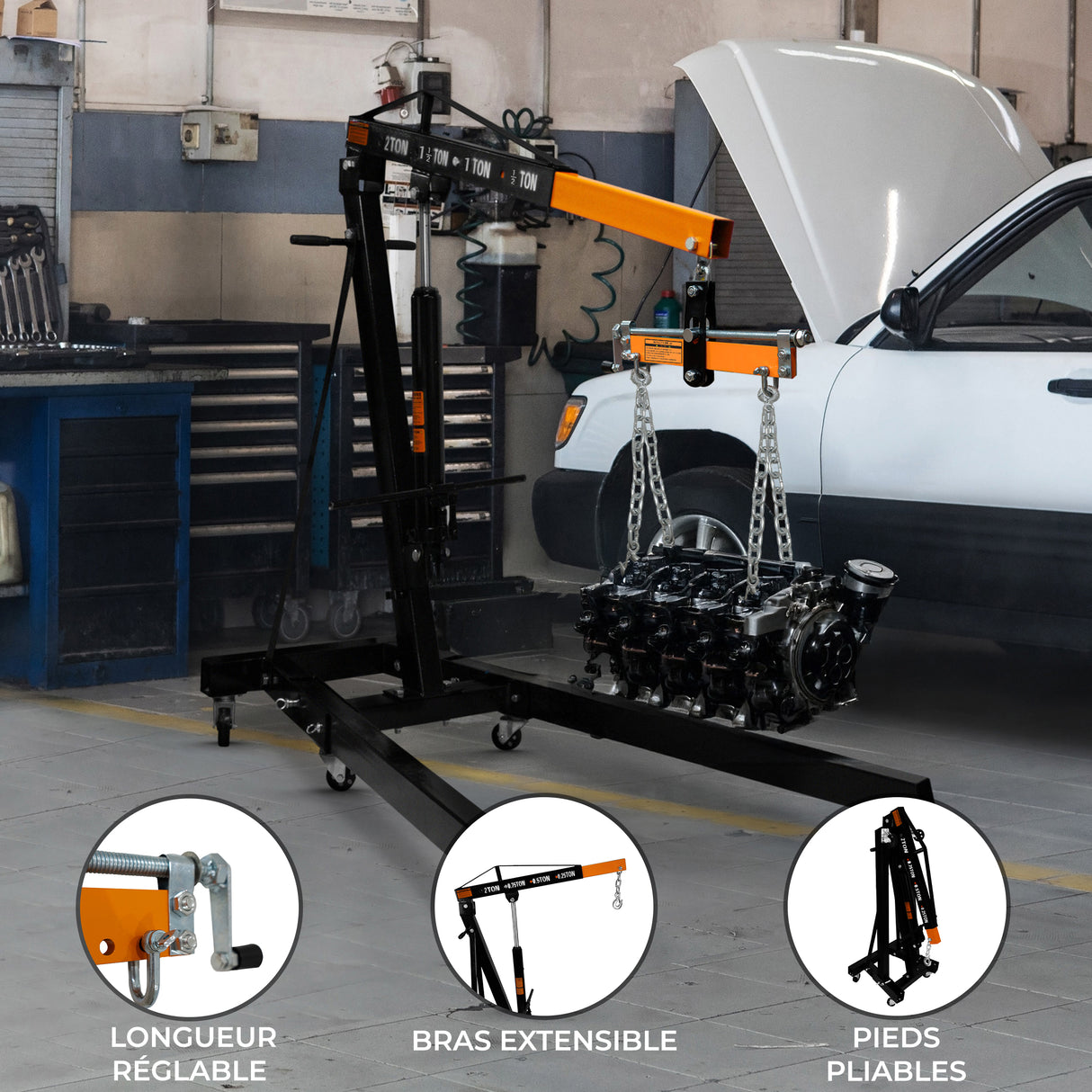 Grue de moteur noire et orange avec bras extensible, charge suspendue, pieds pliables, dans un atelier automobile bien éclairé