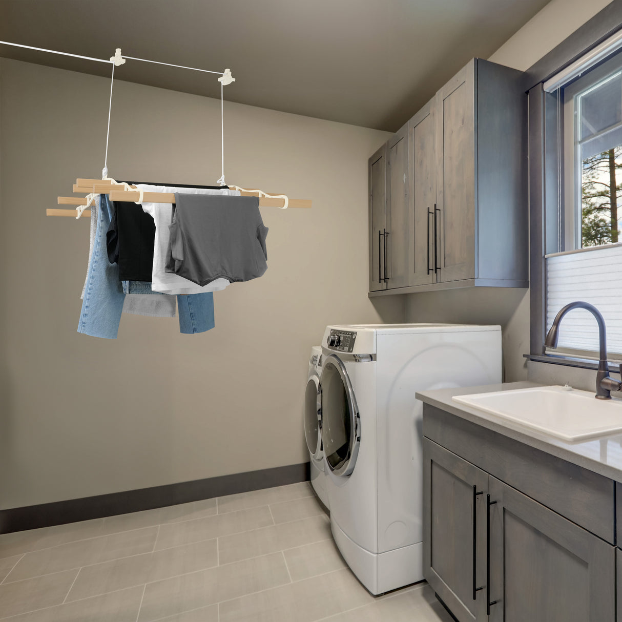 Étendoir à linge suspendu de 2 m en ivoire, avec des vêtements colorés accrochés, dans une buanderie moderne et lumineuse