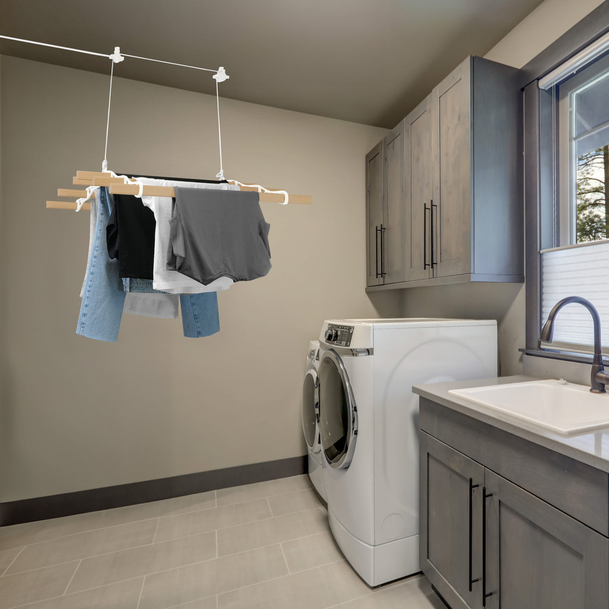 Étendoir à linge suspendu blanc de 0,9 m avec vêtements colorés, installé dans une buanderie moderne avec des armoires grises