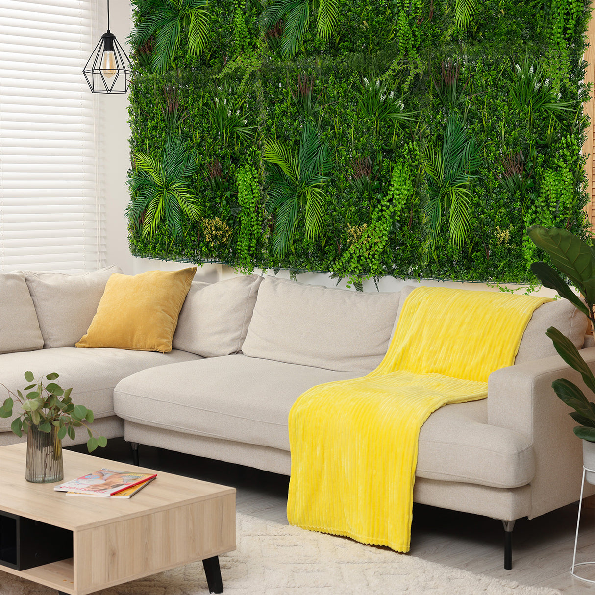 Panneau mural végétal artificiel de 100 x 100 cm, avec des feuillages verts luxuriants, décorant un salon moderne et lumineux