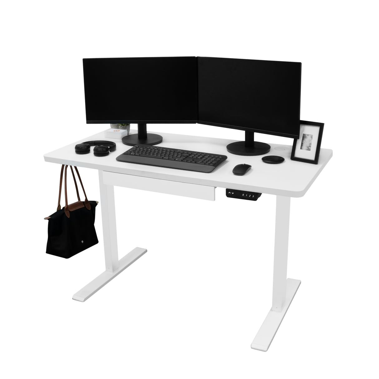 Bureau assis-debout électrique blanc avec tiroir, deux écrans noirs, clavier, souris, et sac à main sur le côté