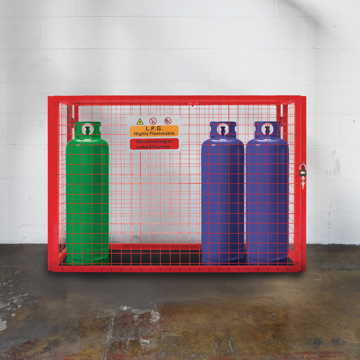 Cage métallique rouge pour bouteilles de gaz, avec trois bouteilles colorées, vert, bleu et rouge, sur un sol en béton texturé