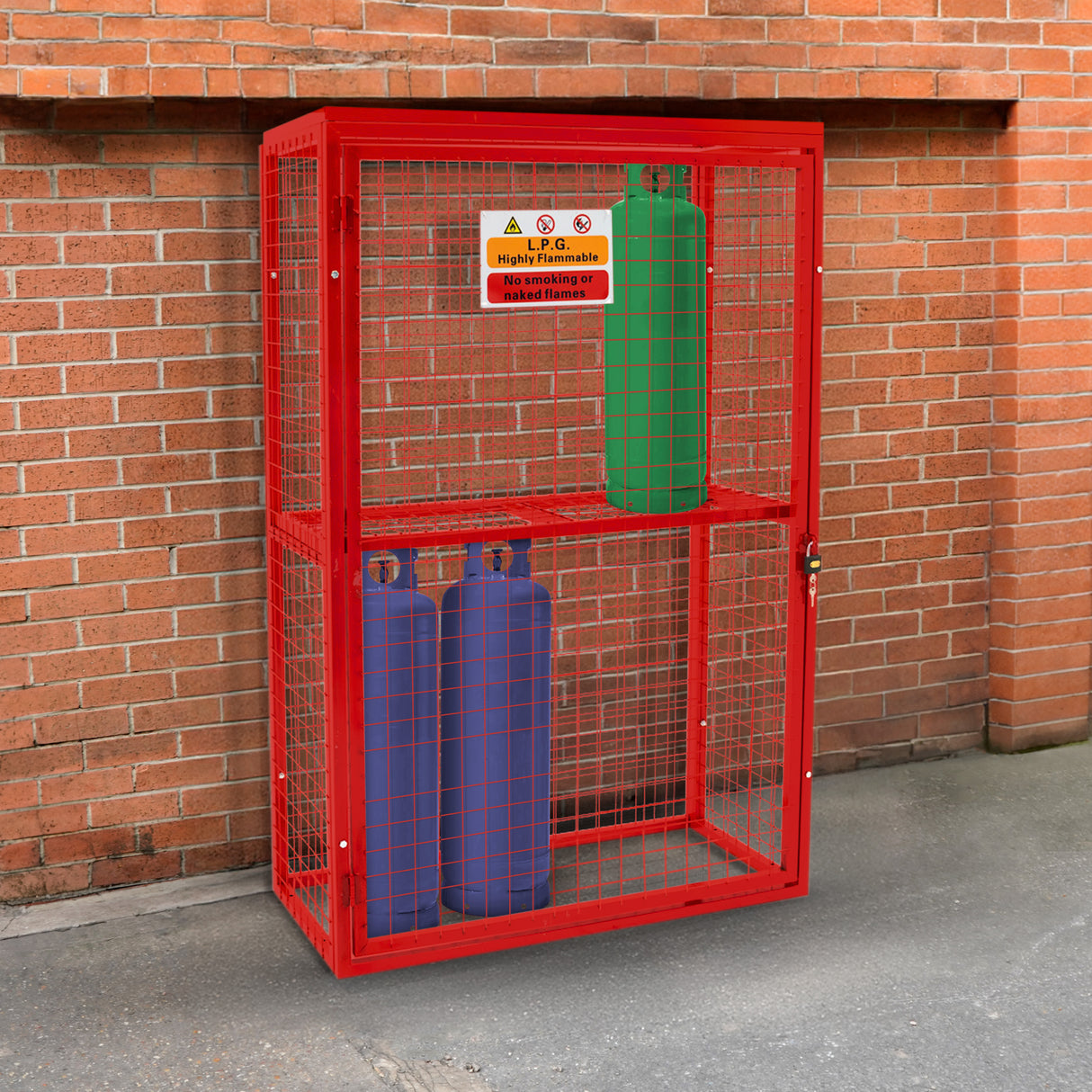 Cage métallique rouge pour bouteilles de gaz, avec deux bouteilles bleues et vertes à l'intérieur, sur fond de mur en briques