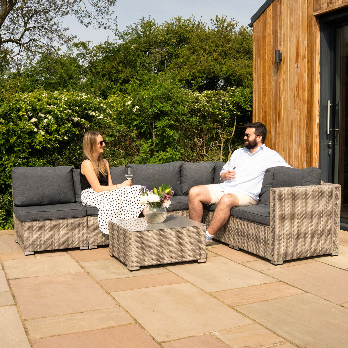 Salon de jardin modulaire en rotin gris, 7 pièces, avec coussins confortables, table basse en verre, ambiance conviviale en extérieur