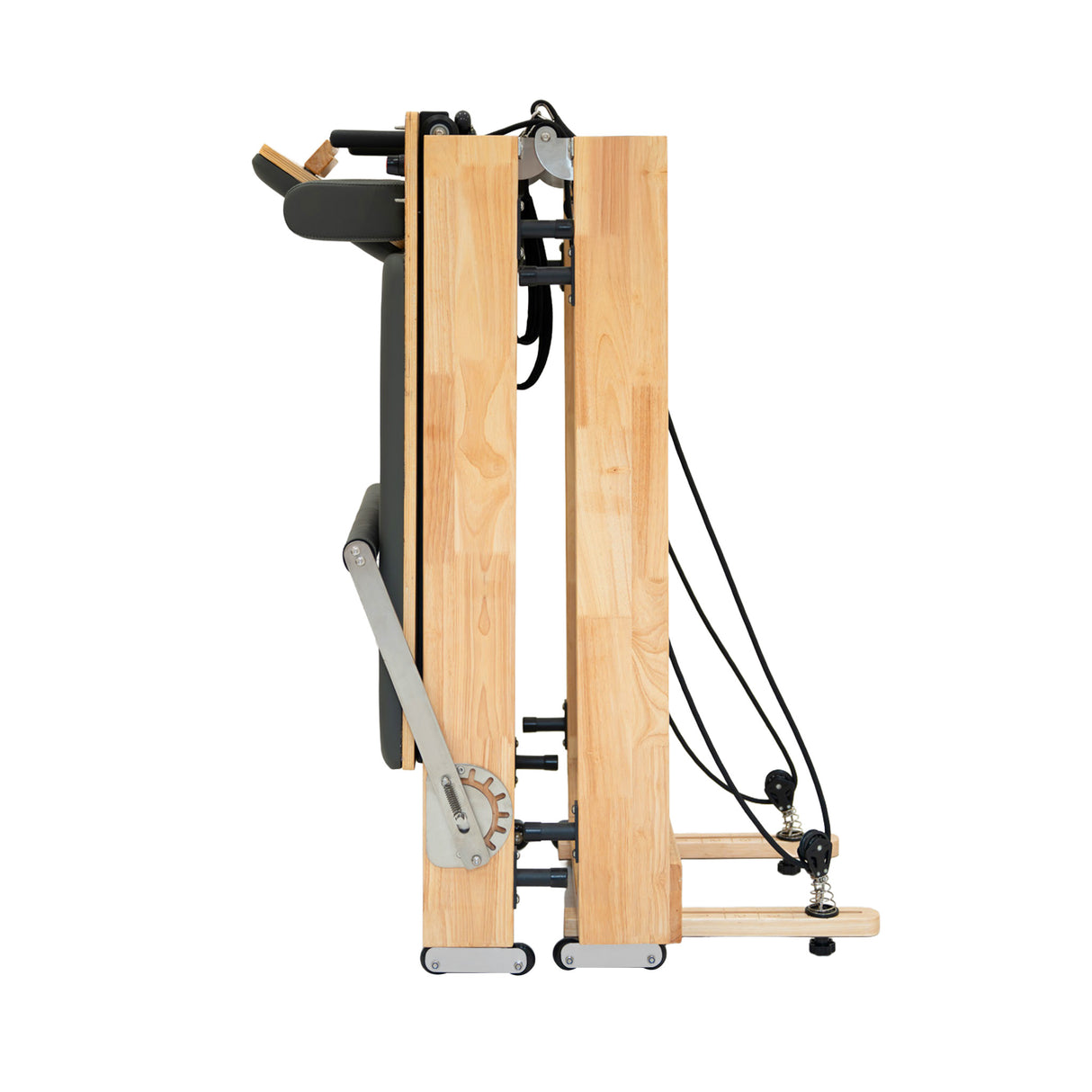 Machine reformer Pilates pliable en chêne, finition lisse, design compact, cordes noires et roulettes pour un rangement facile