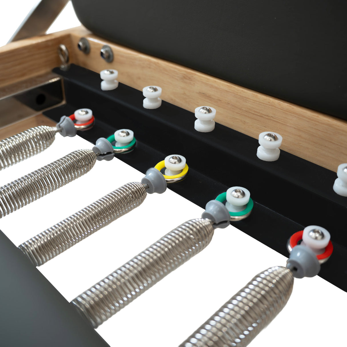 Machine reformer Pilates pliable en chêne, avec ressorts métalliques, boutons colorés et surface en cuir noir pour un confort optimal