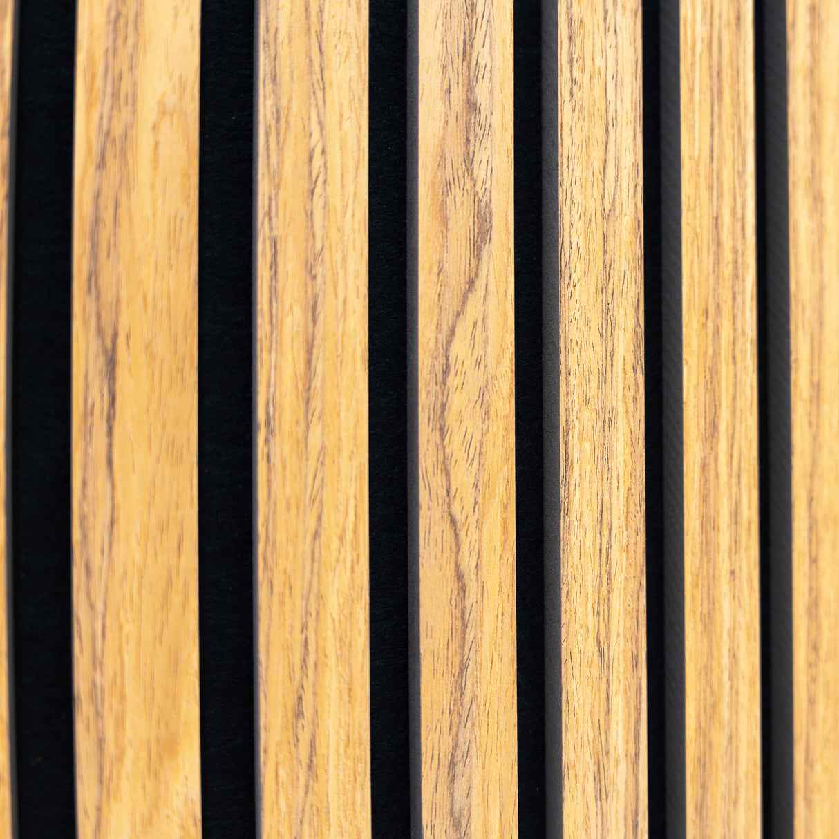 Panneaux acoustiques muraux en chêne avec des lattes en bois clair et des espaces noirs, offrant une texture élégante et moderne