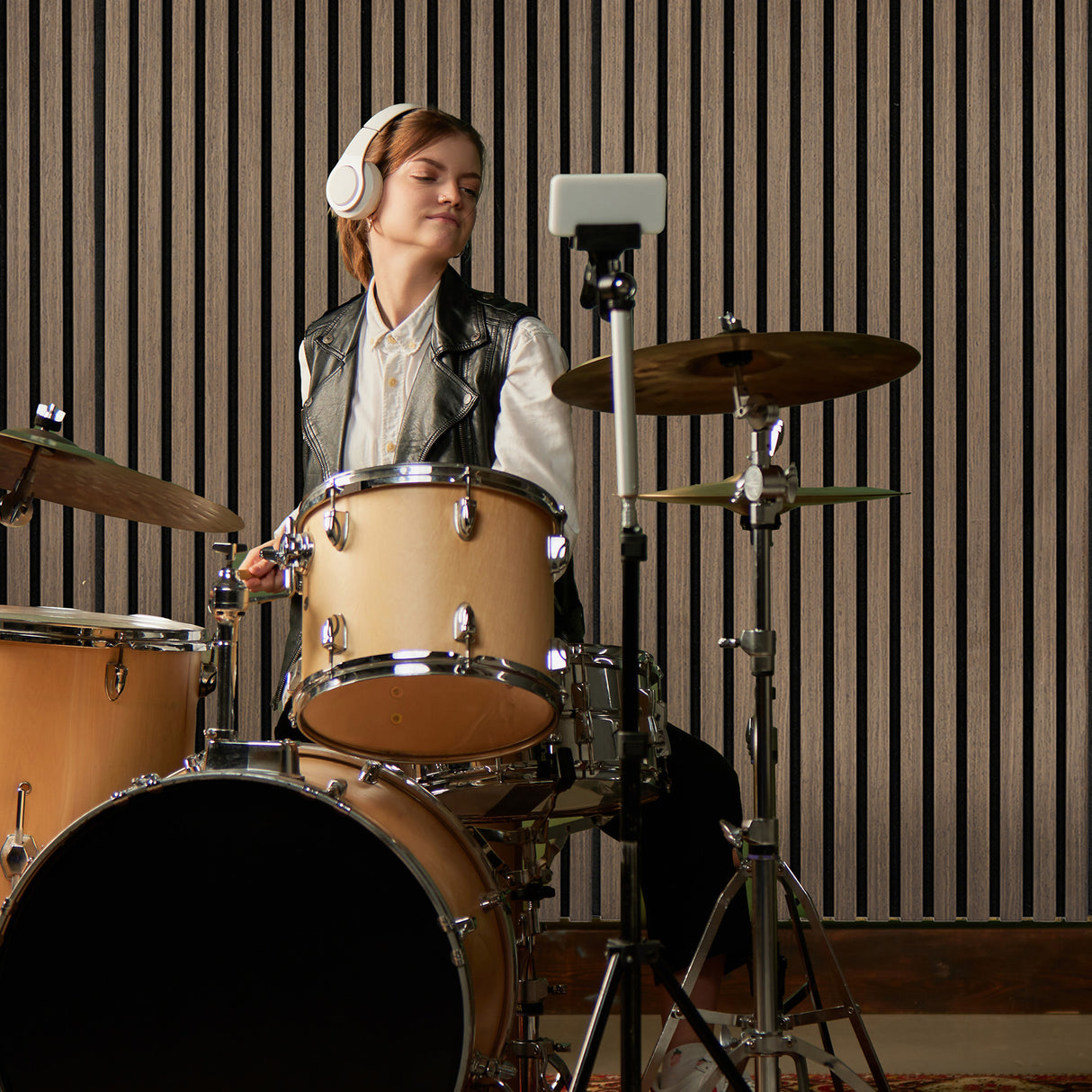 Panneaux lattes acoustiques muraux en noyer foncé, ajoutant une texture élégante et un design moderne à un studio de musique
