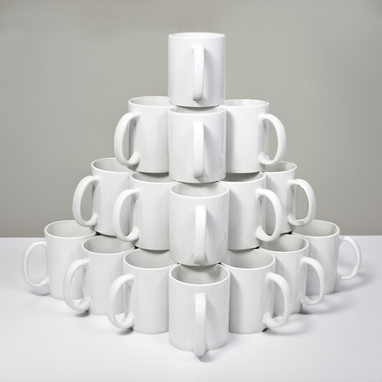 Tasses blanches en céramique empilées en pyramide, idéales pour la sublimation, avec des poignées ergonomiques et une finition lisse