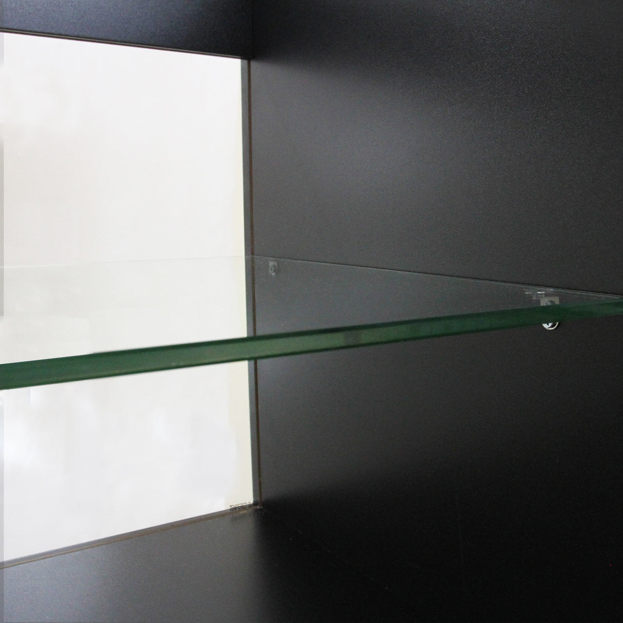 Étagère en verre transparent sur un fond noir, avec des bords nets et une finition élégante, idéale pour une présentation moderne
