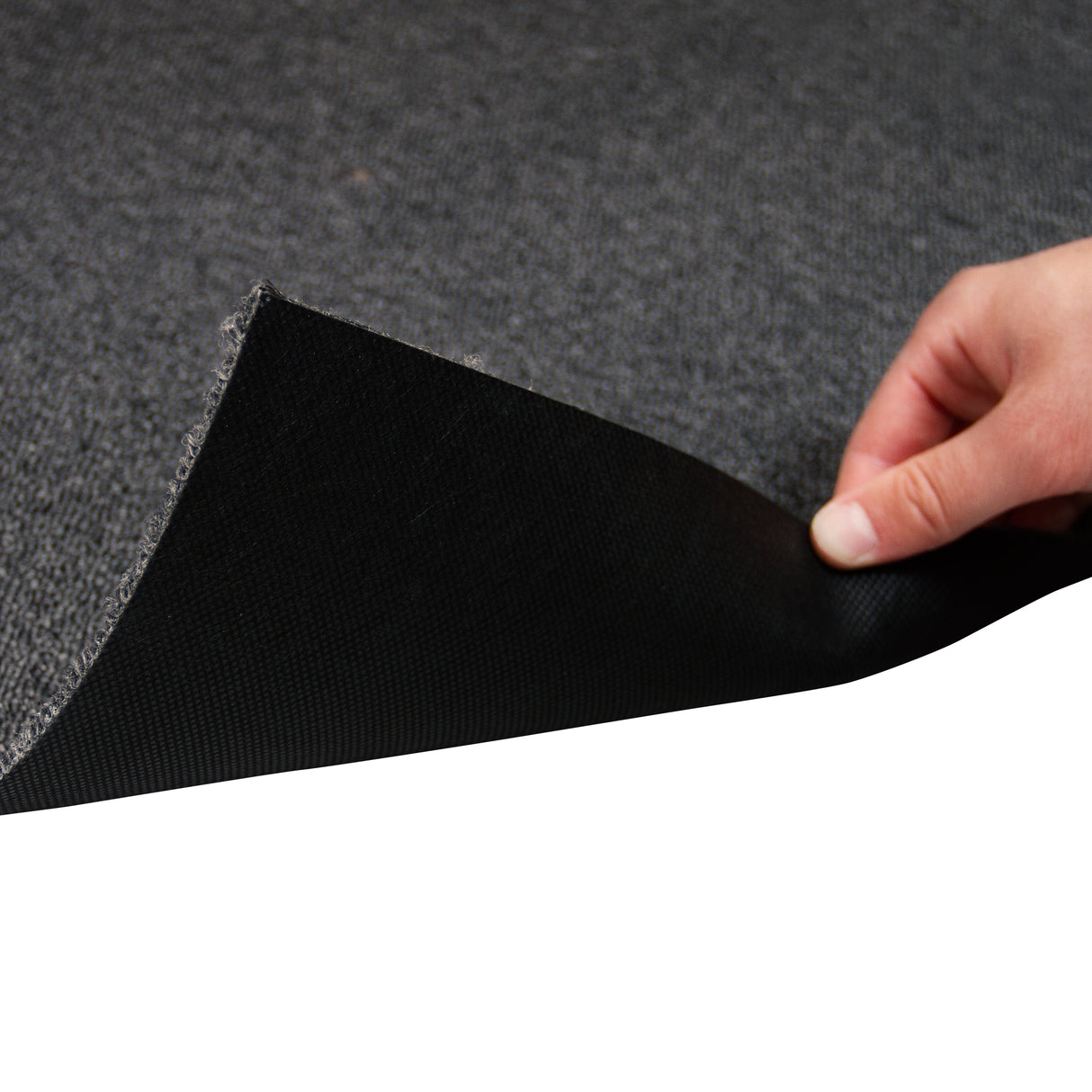 Dalles de moquette noir charbon de 50cm x 50cm, texture douce et résistante, montrant un coin relevé pour révéler le dessous antidérapant