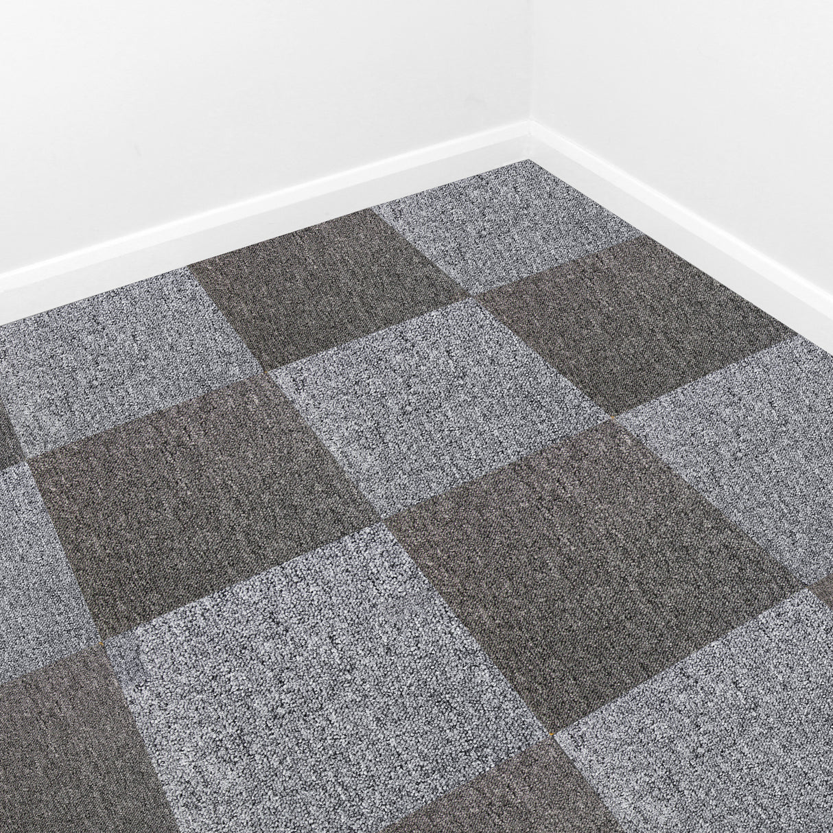 Dalles de moquette gris platine en texture douce, disposées en motif quadrillé sur un sol clair, créant un espace moderne et élégant