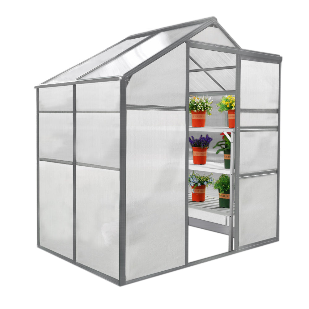 Serre de jardin en métal gris, 1,8 m x 1,2 m, avec parois transparentes, étagères blanches et plantes en pots colorés à l'intérieur
