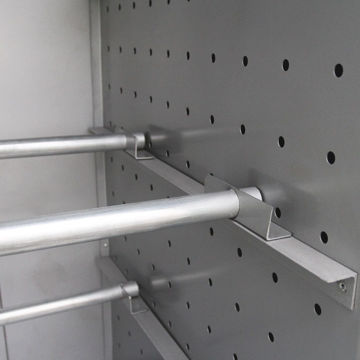 Supports en métal argenté à l'intérieur d'un four de séchage, avec des perforations sur les parois pour une circulation d'air optimale