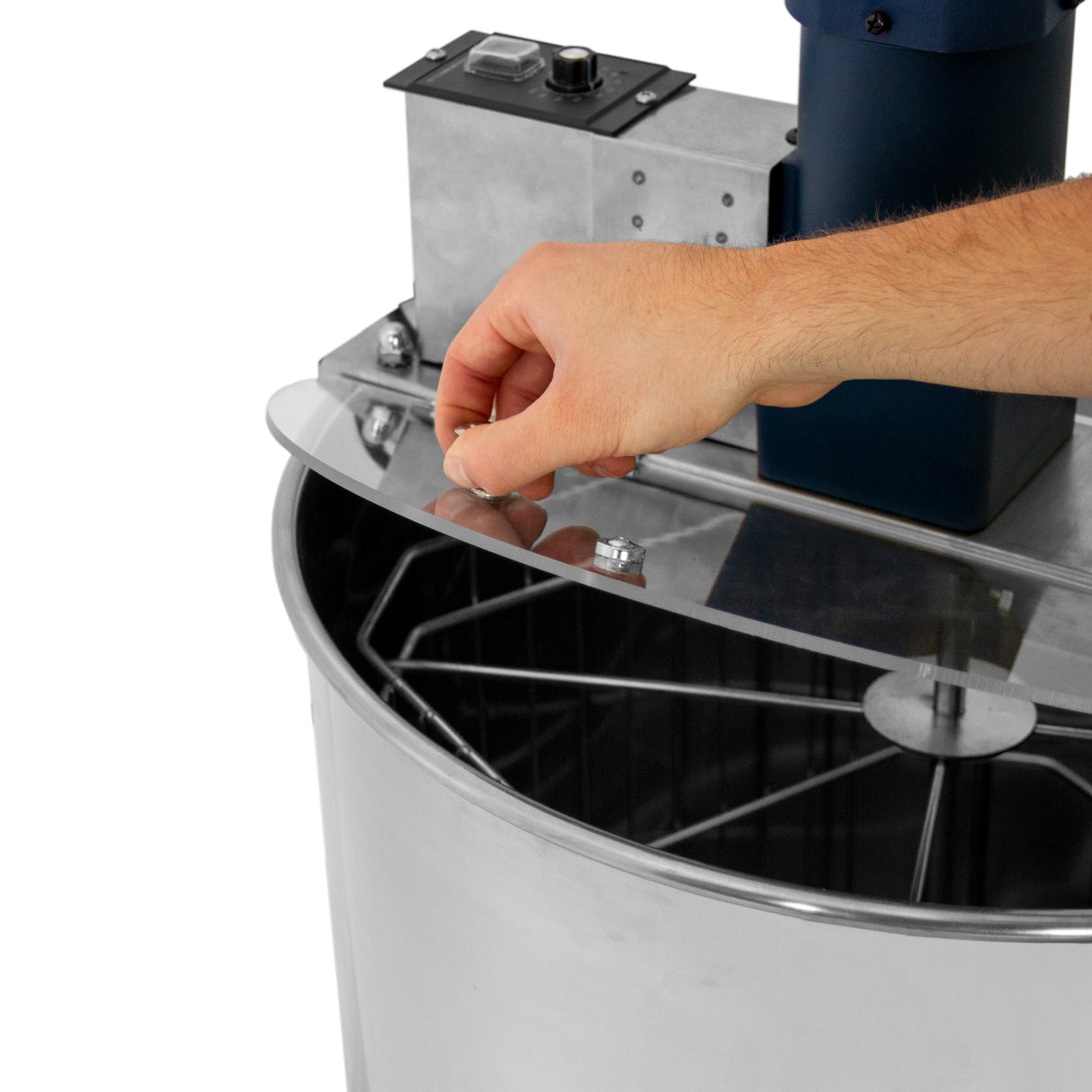 Extracteur de miel électrique T-Mech avec un couvercle transparent et un moteur bleu, main ajustant le couvercle en acier inoxydable